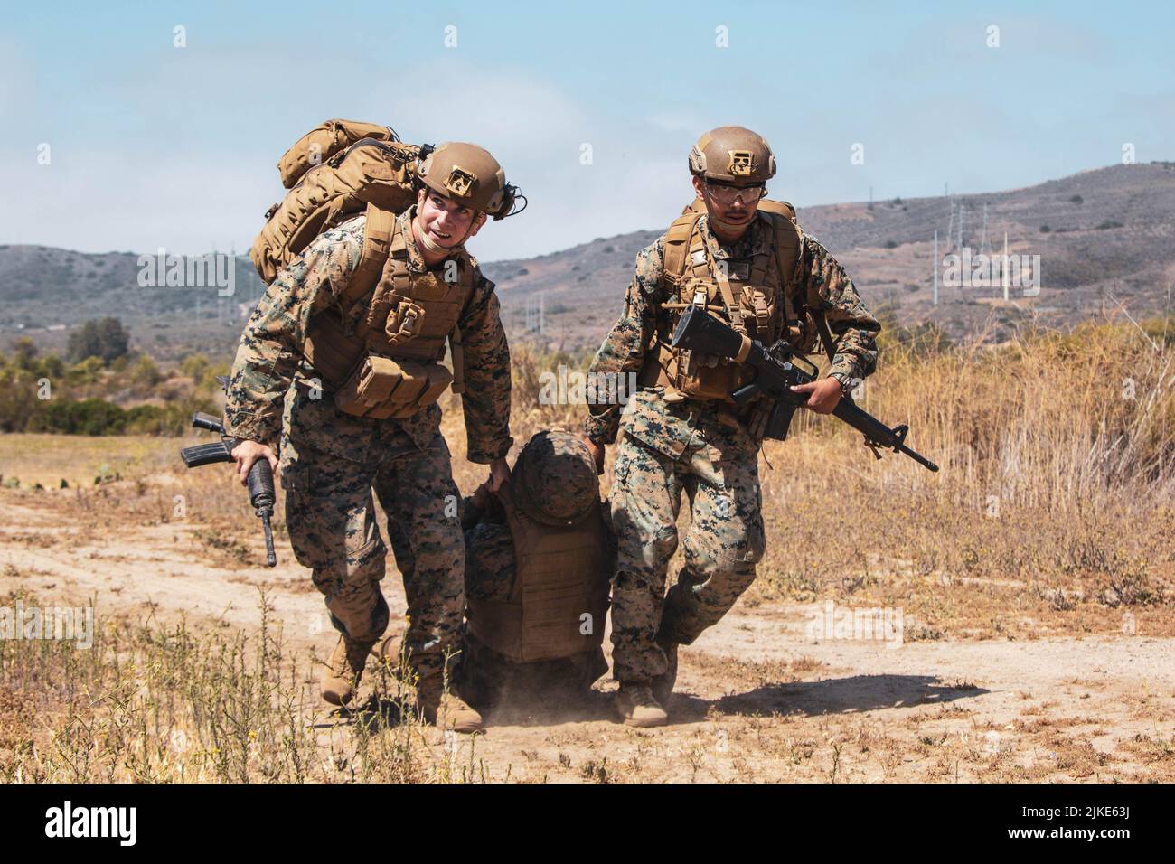 I Corpsmen dell'ospedale della Marina degli Stati Uniti con i forza di spedizione marina trascinano il loro incidente al punto di raccolta della casualità (CCP) durante un corso di integrazione medica di spedizione (EPIC) su Camp Pendleton, California 6 maggio 2022. Il gruppo EOTG (Expeditionary Operations Training Group) ha condotto l'EPIC per porre le basi delle competenze e delle conoscenze necessarie al personale medico MEU per fornire i più alti livelli di capacità di supporto ai servizi sanitari in qualsiasi ambiente operativo. Foto Stock