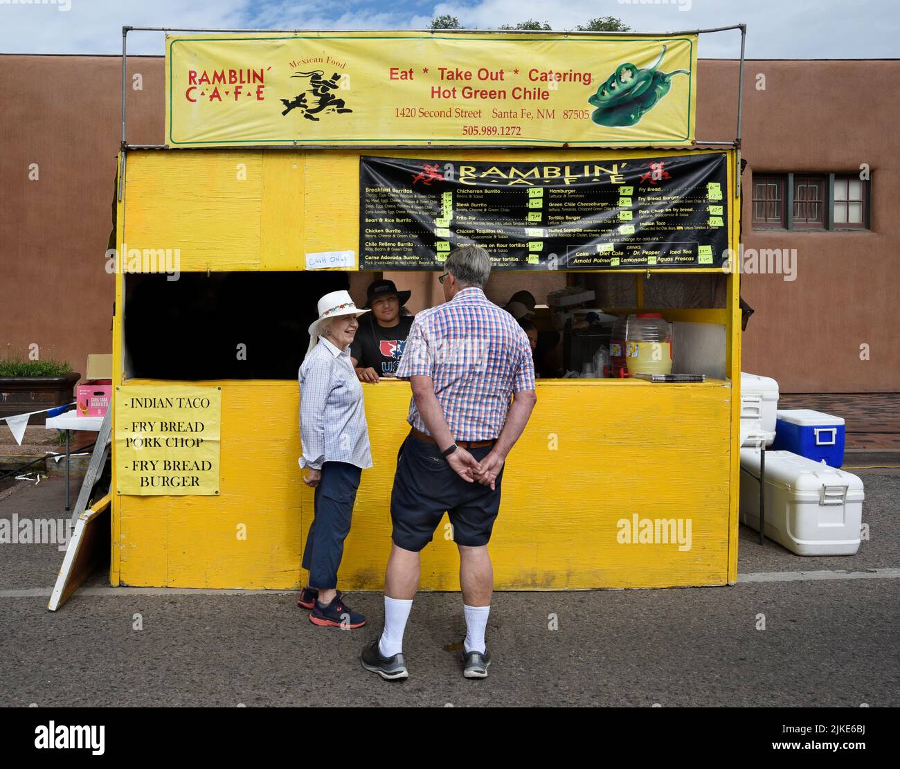 Una coppia senior considera cosa acquistare da un fornitore di cibo in un festival all'aperto a Santa Fe, New Mexico. Foto Stock