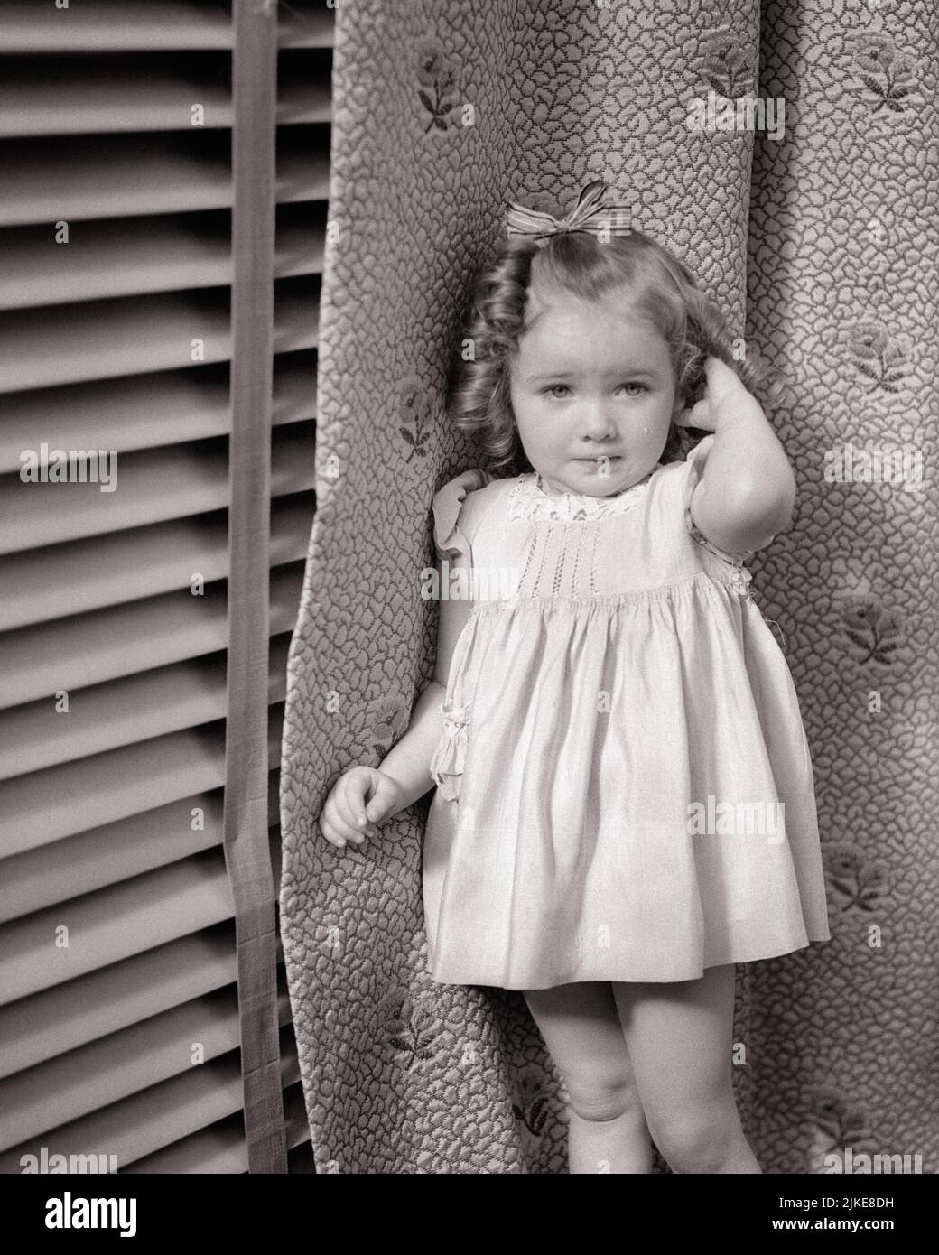 1930S 1940S RAGAZZA TIMIDA VESTIRE BALONEY RICCIOLI ARCO IN CAPELLI ESPRESSIONE FACCIALE INCERTA IN PIEDI DA TENDE LACRIME SULLA GUANCIA - J772 HAR001 HARS PAURA TRAVAGLIATO VENEZIANO B&W INTERESSATO TRISTEZZA BRUNA ANSIA PIANGERE ANSIOSO RICCI DRAPPI UMORE SOBBING GLUM MINACCIATO TIMIDO TIMIDO TIMIDO TIMIDO PAUROSO BALONEY GIOVANI MISERABILE BAMBINO RAGAZZA BASHFUL NERO E BIANCO ETNIA CAUCASICA HAR001 VECCHIO STILE INCERTO Foto Stock