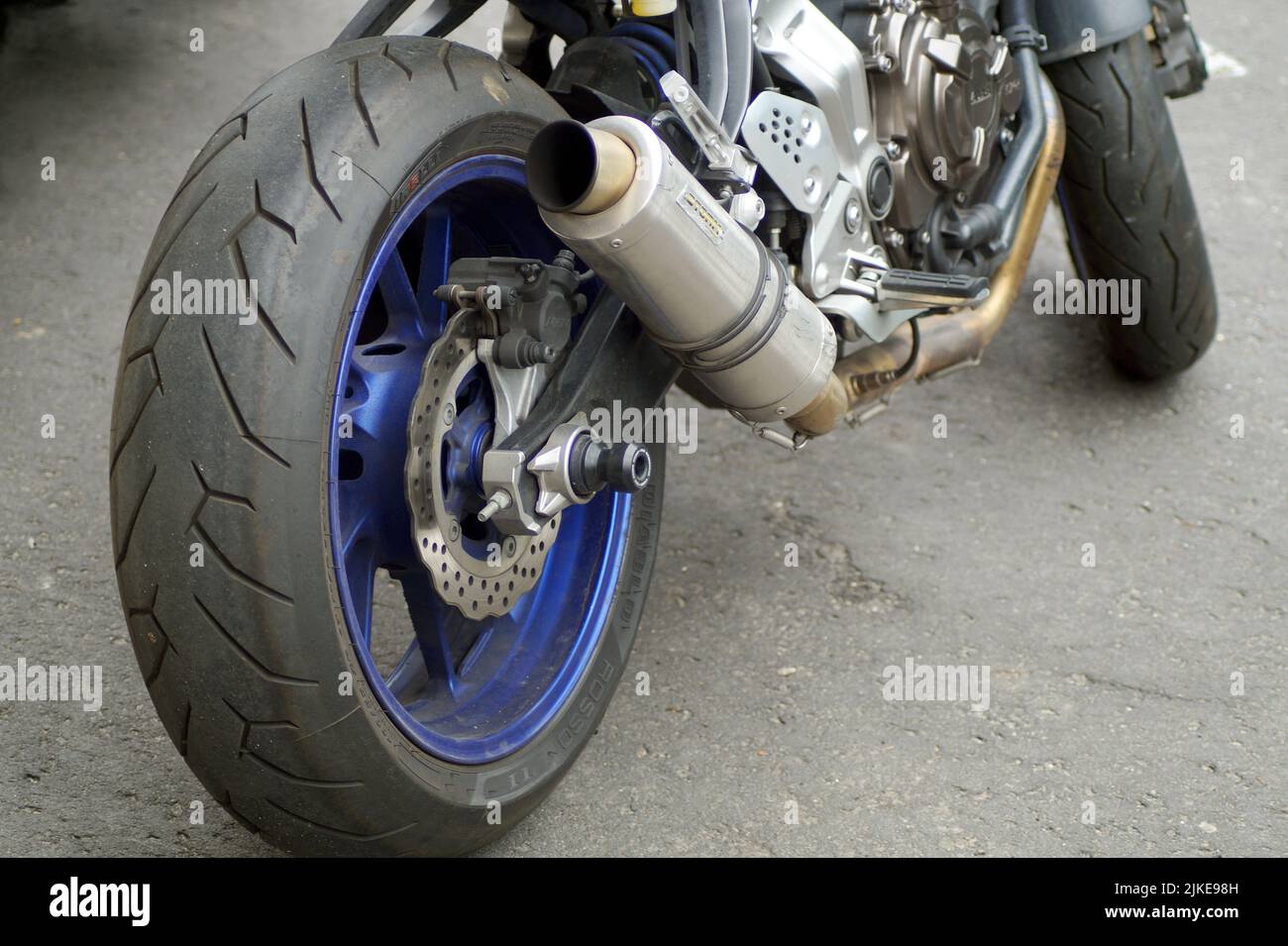 la foto mostra una parte di una motocicletta sportiva - la ruota posteriore, il tubo di scarico, preso molto vicino Foto Stock
