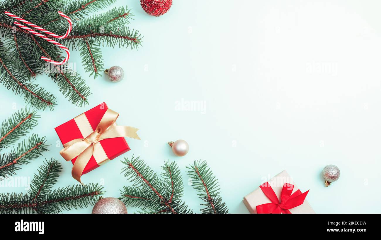 Decorazioni natalizie, scatole regalo, rami di abete e canna da zucchero su sfondo chiaro. Vista dall'alto, disposizione piatta, spazio di copia. Foto Stock