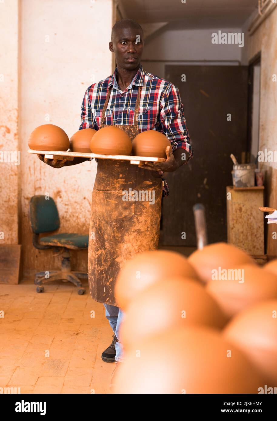 Uomo che trasporta i prodotti di creta in ceramica Foto Stock