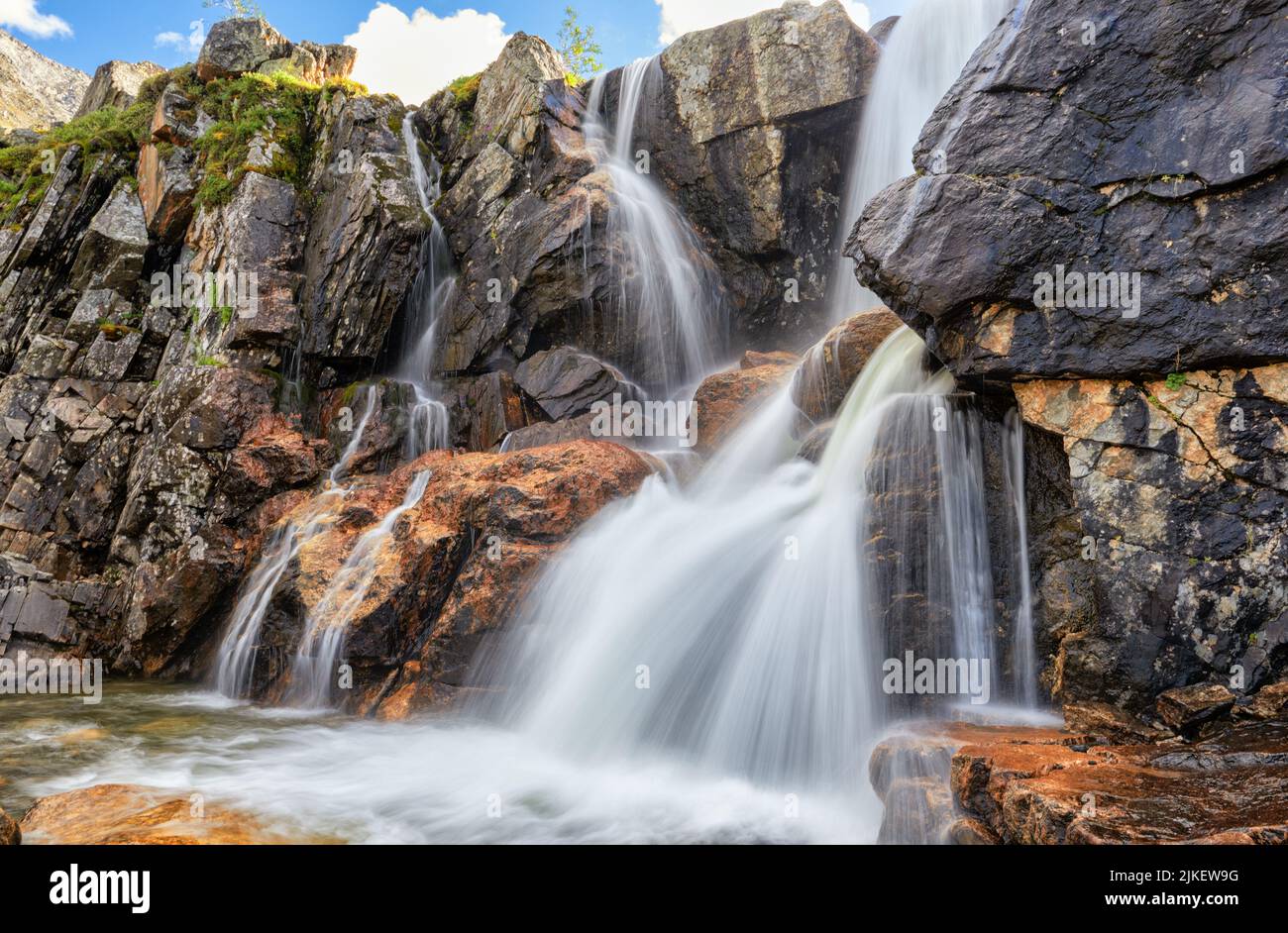 Bellissima cascata nella tundra di montagna. Sayan orientale. Buryatia. Scatto a lunga esposizione Foto Stock