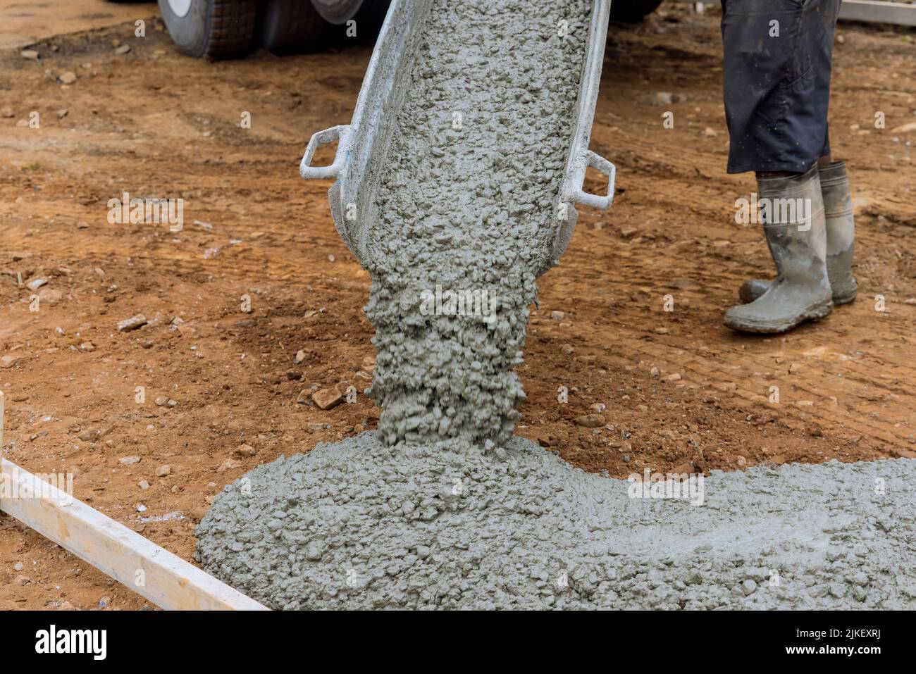 Durante la costruzione di un vialetto, il calcestruzzo bagnato viene versato sulla parte superiore Foto Stock
