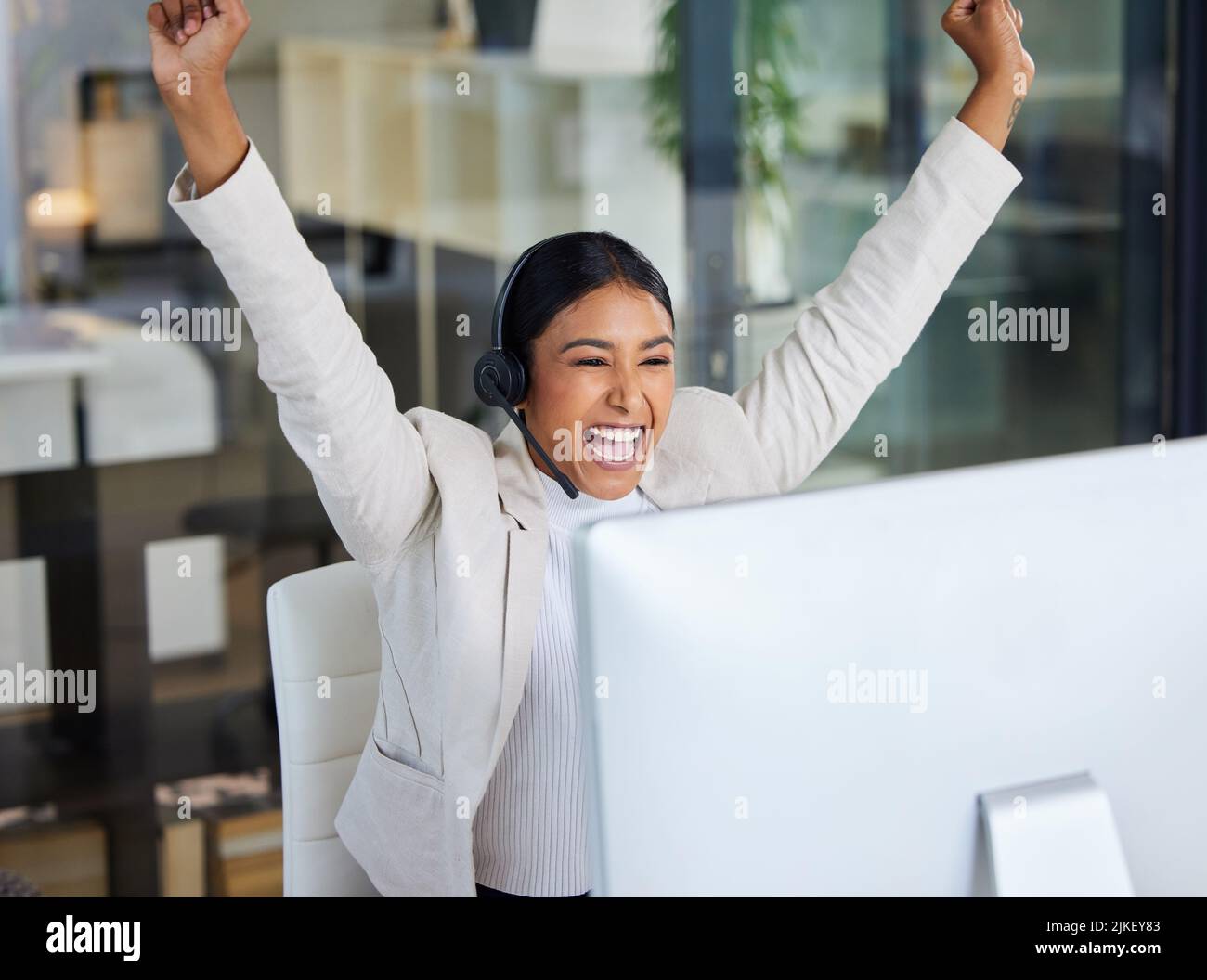 Convalida immediata da parte tua davvero. Una giovane donna che lavora in un call center ha catturato in un momento di vittoria in un ufficio moderno. Foto Stock