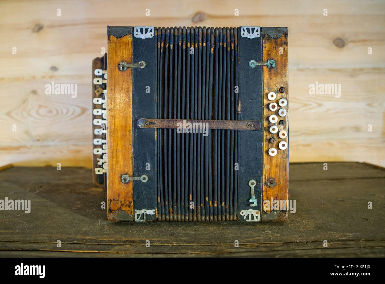 Un vecchio strumento musicale a fisarmonica con una vecchia cassa usurata e pellicce leggermente lacerate Foto Stock