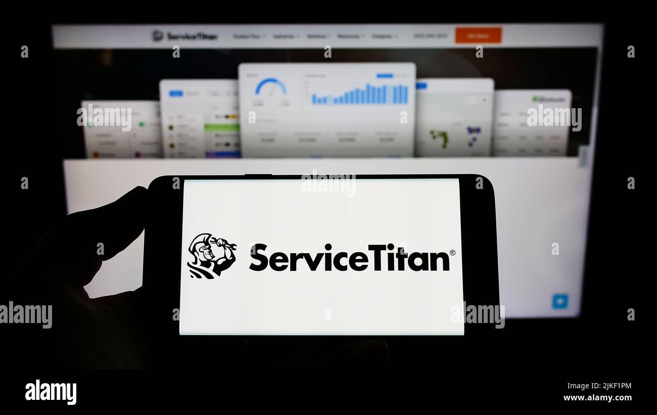 Persona che tiene il telefono cellulare con il logo della società americana di software ServiceTitan Inc. Sullo schermo di fronte alla pagina web. Mettere a fuoco sul display del telefono. Foto Stock Persona che tiene il telefono cellulare con il logo della società americana di software ServiceTitan Inc. Sullo schermo di fronte alla pagina web. Mettere a fuoco sul display del telefono. Foto Stock