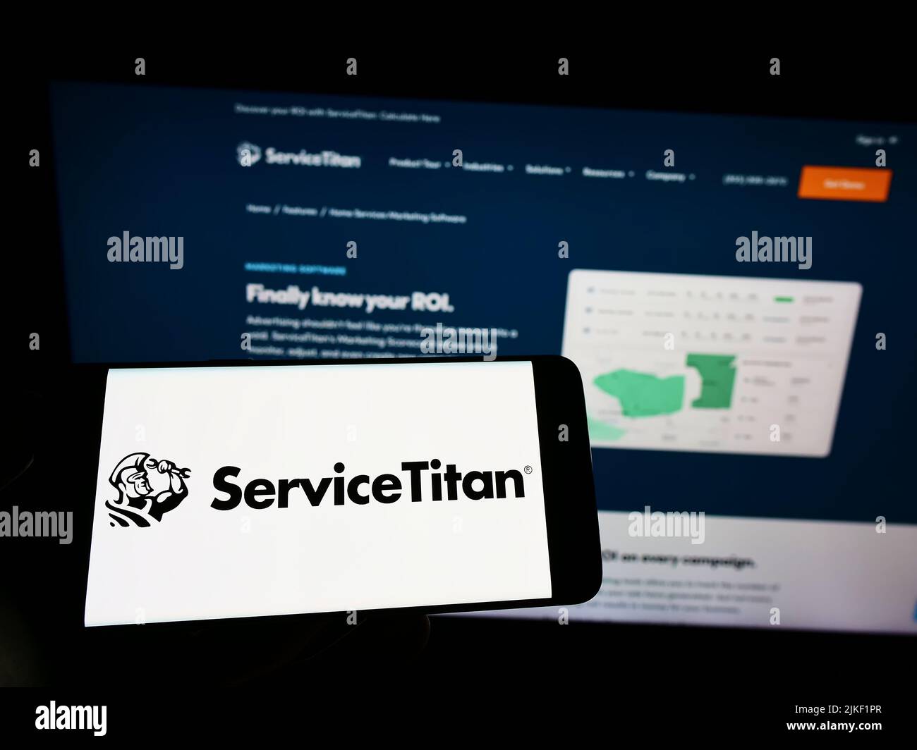 Persona che tiene il cellulare con il logo della società di software statunitense ServiceTitan Inc. Sullo schermo di fronte al sito web aziendale. Mettere a fuoco sul display del telefono. Foto Stock Persona che tiene il cellulare con il logo della società di software statunitense ServiceTitan Inc. Sullo schermo di fronte al sito web aziendale. Mettere a fuoco sul display del telefono. Foto Stock