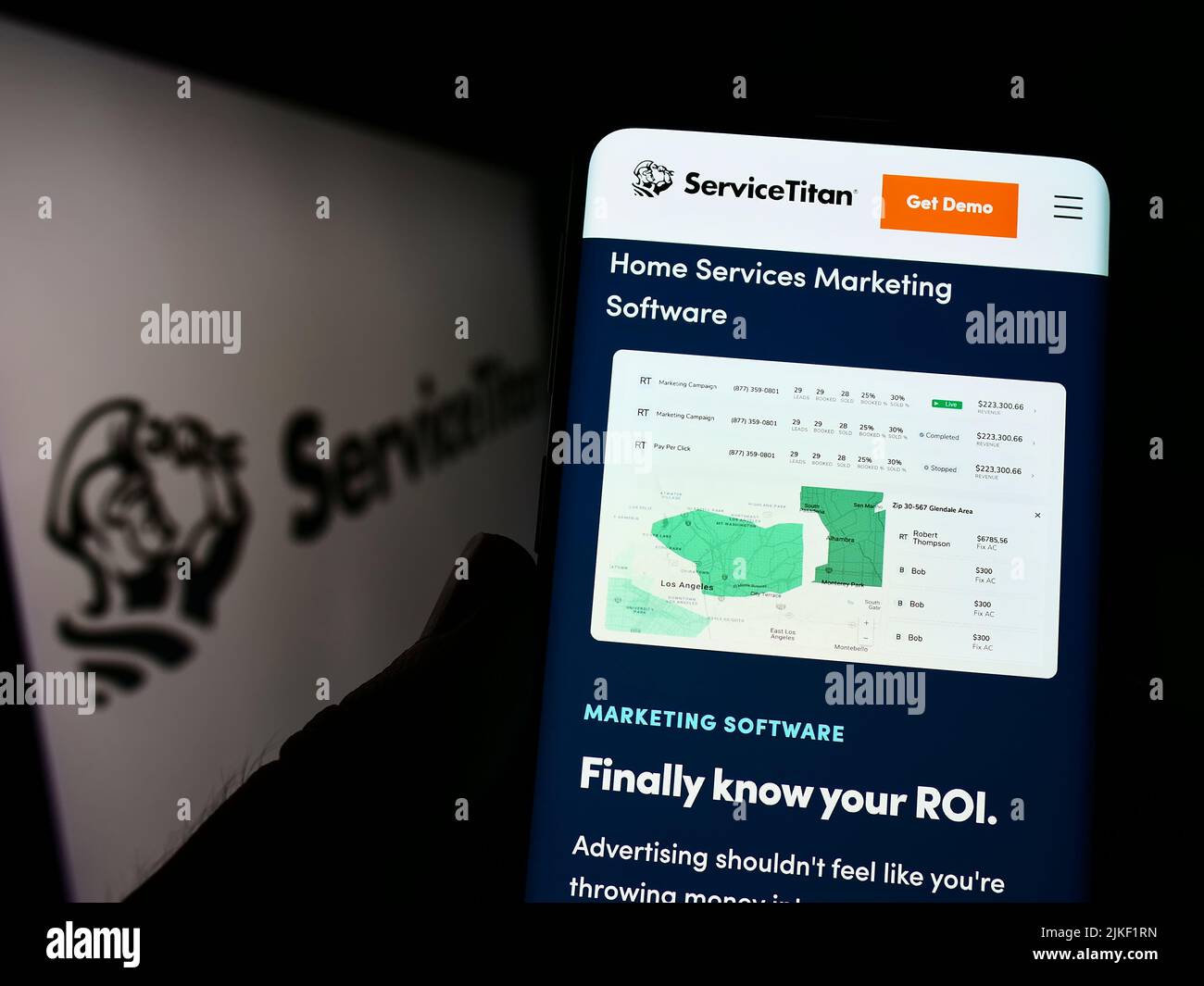Persona che tiene lo smartphone con la pagina Web della società di software statunitense ServiceTitan Inc. Sullo schermo davanti al logo. Concentrarsi sul centro del display del telefono. Foto Stock