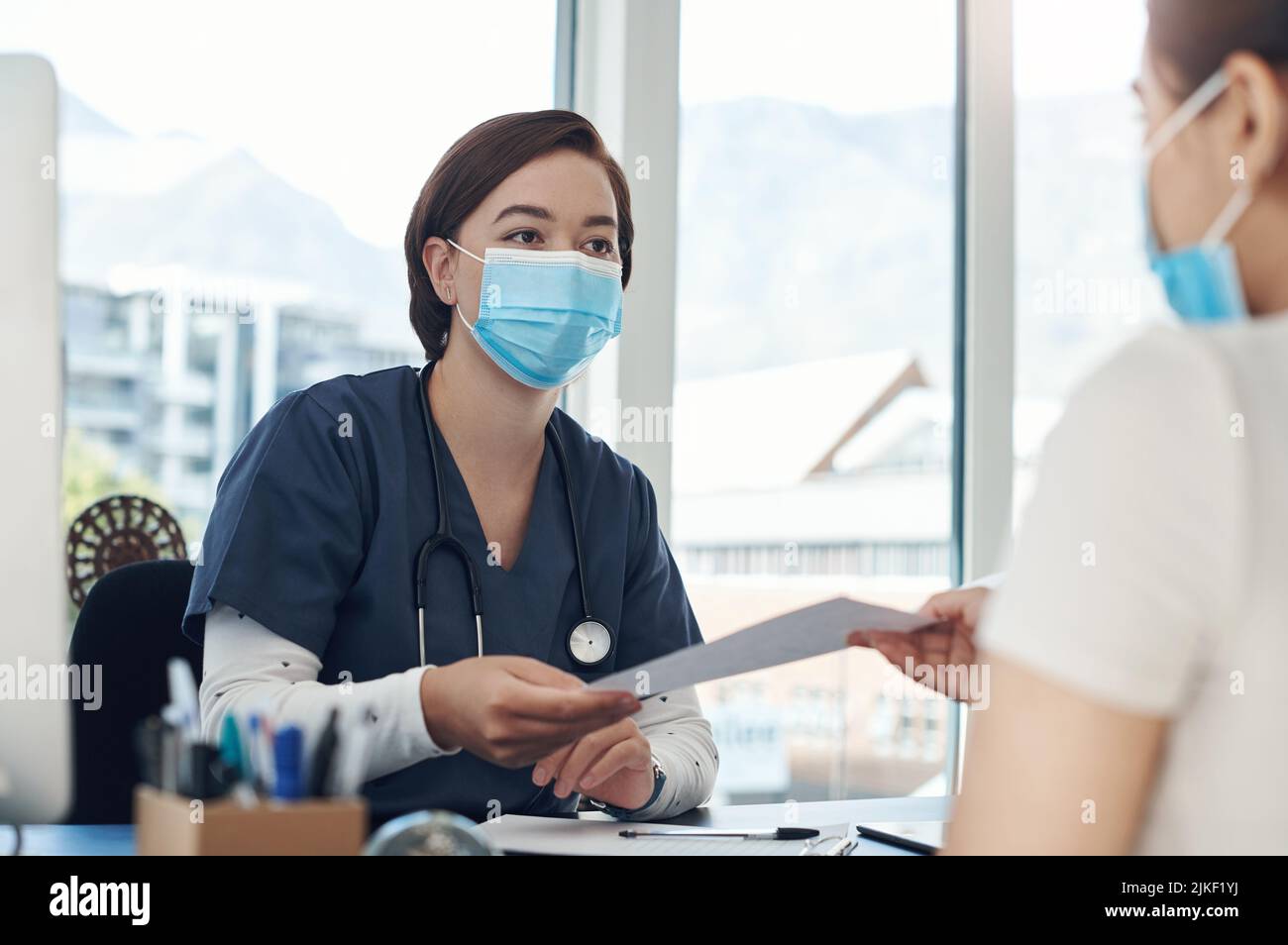 Ecco un elenco di cose da ricordare: Una giovane dottore femminile che dà un documento ad un paziente in un ufficio. Foto Stock