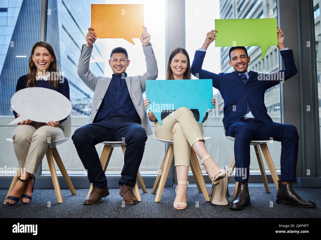 Erano un team molto diversificato, un gruppo di giovani uomini d'affari che tenevano bolle d'espressione mentre aspettavano in fila. Foto Stock