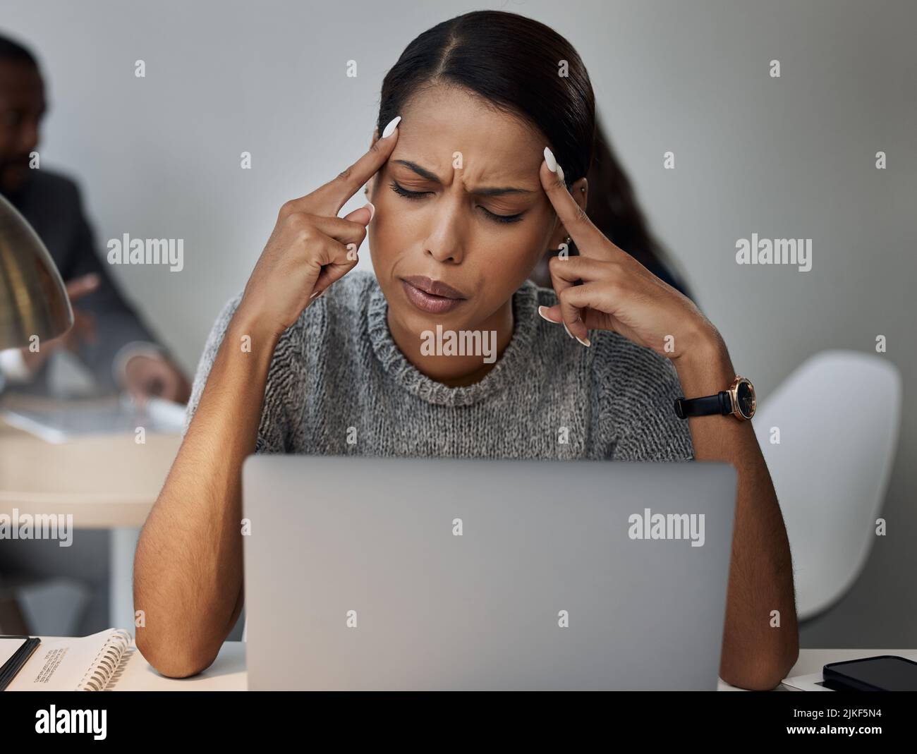 Non ho idea di come questo possa essere fatto: Una giovane donna d'affari che vive un mal di testa mentre lavora. Foto Stock