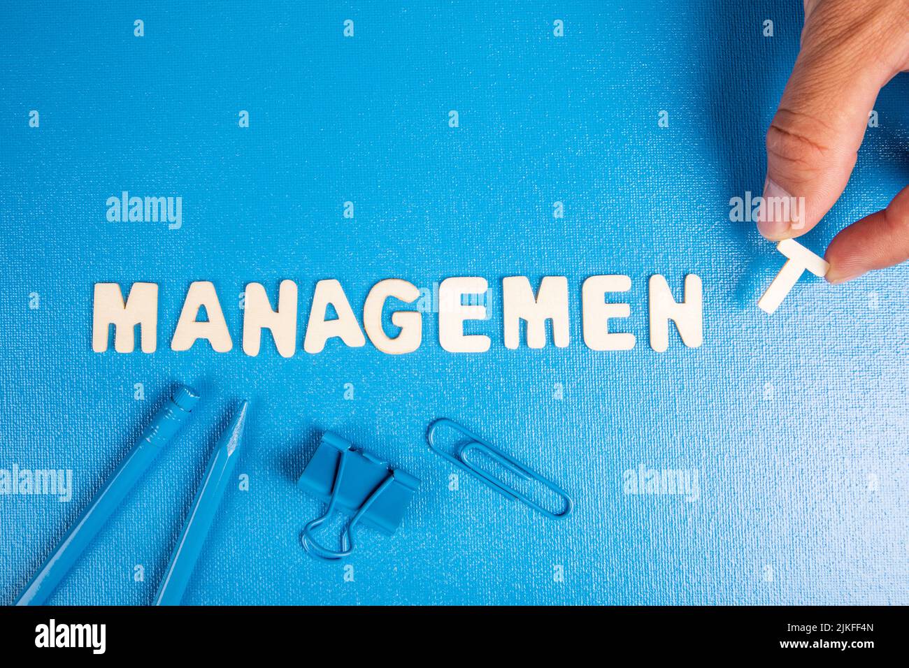 Concetto di gestione. Testo da lettere bianche di legno su sfondo blu. Foto Stock