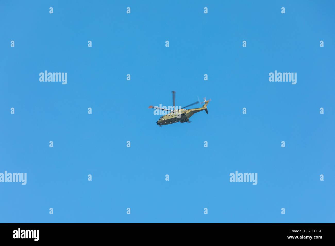 Elicottero militare Super Puma non marcato che vola sopra il cielo blu della Danimarca Foto Stock