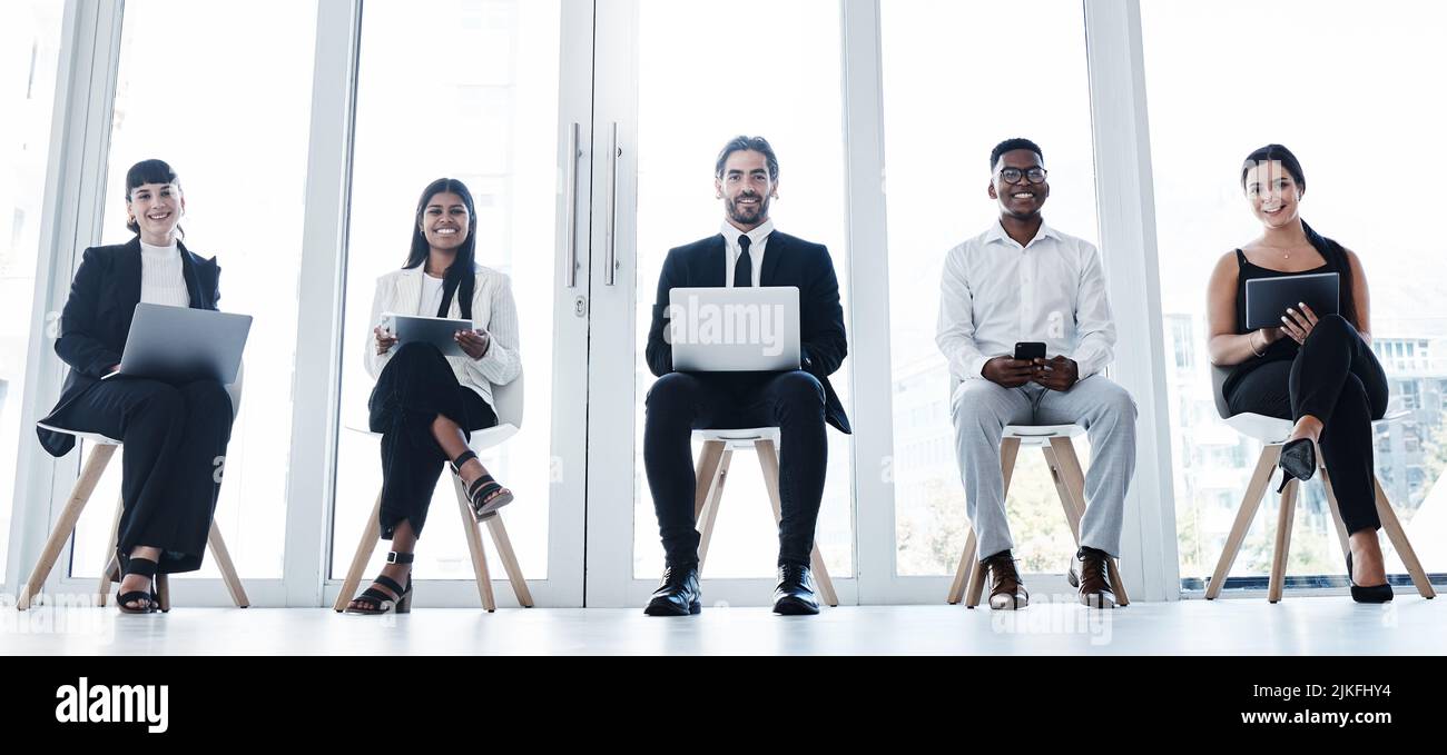 Gioco d'attesa. Un gruppo di uomini d'affari che utilizzano dispositivi digitali in ufficio. Foto Stock