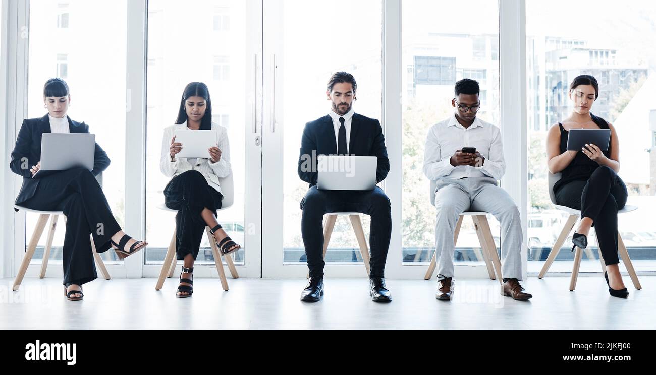 Un gruppo di aziende che utilizzano dispositivi digitali in ufficio. Foto Stock