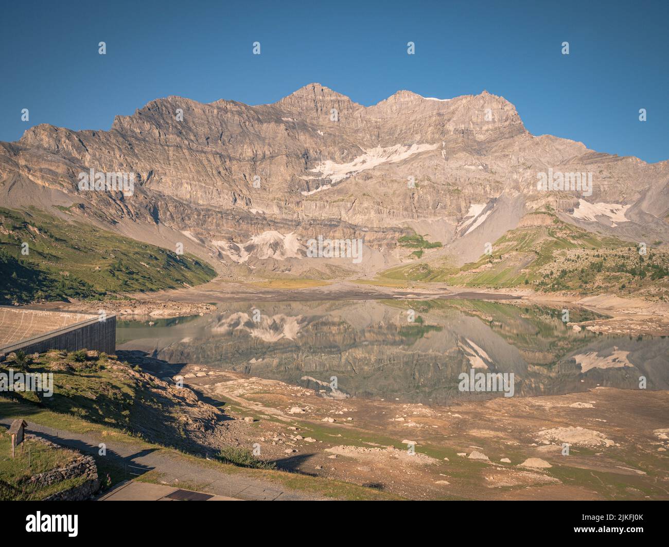 Bella valle alpina. I pini fiancheggiano un ripido versante montano e le alte cime svaniscono in lontananza. Foto Stock