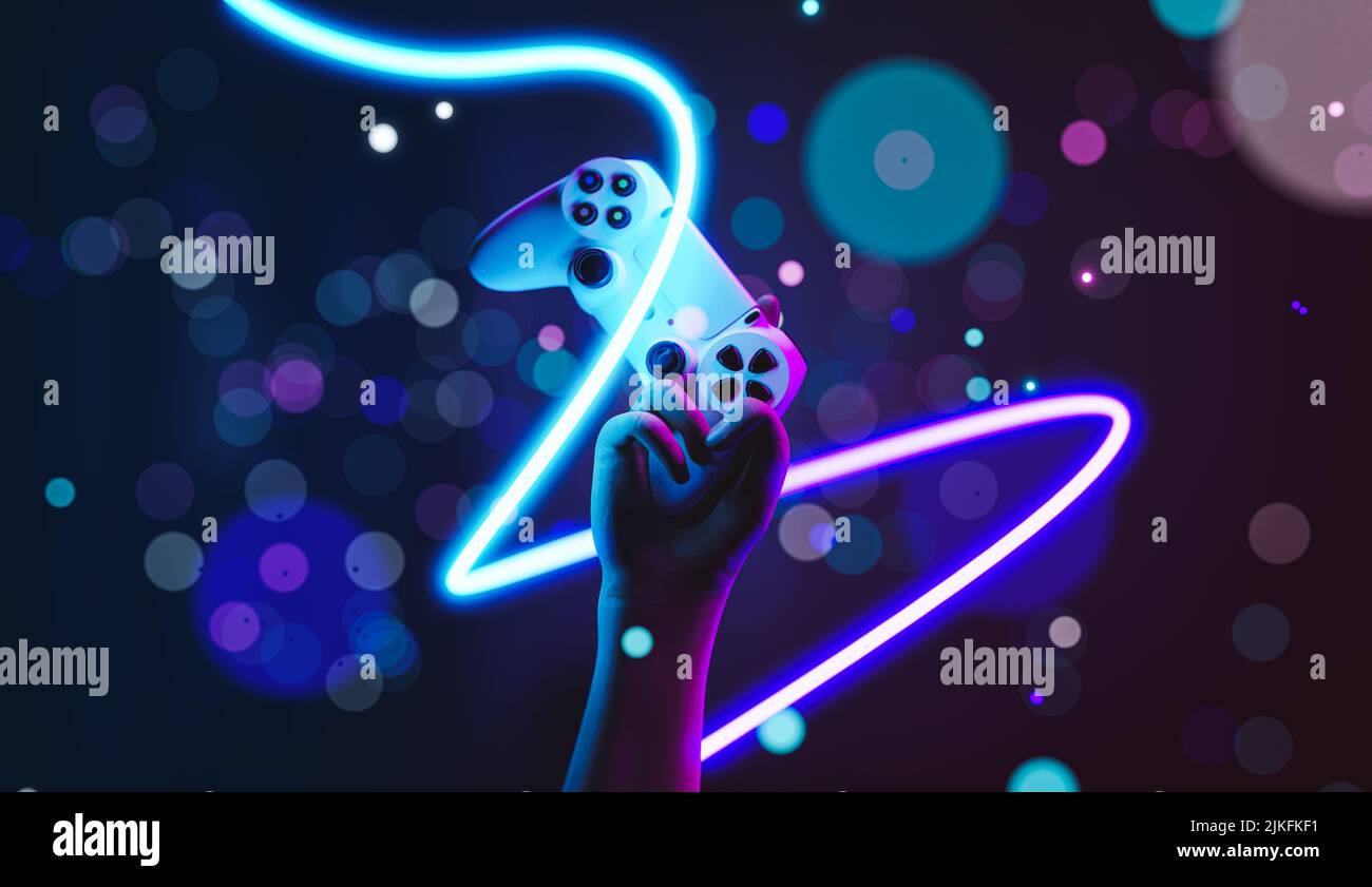 Gamepad in mani rialzate - concetto di giocare e vincere in eSport - sfondo neon con effetto bokeh Foto Stock