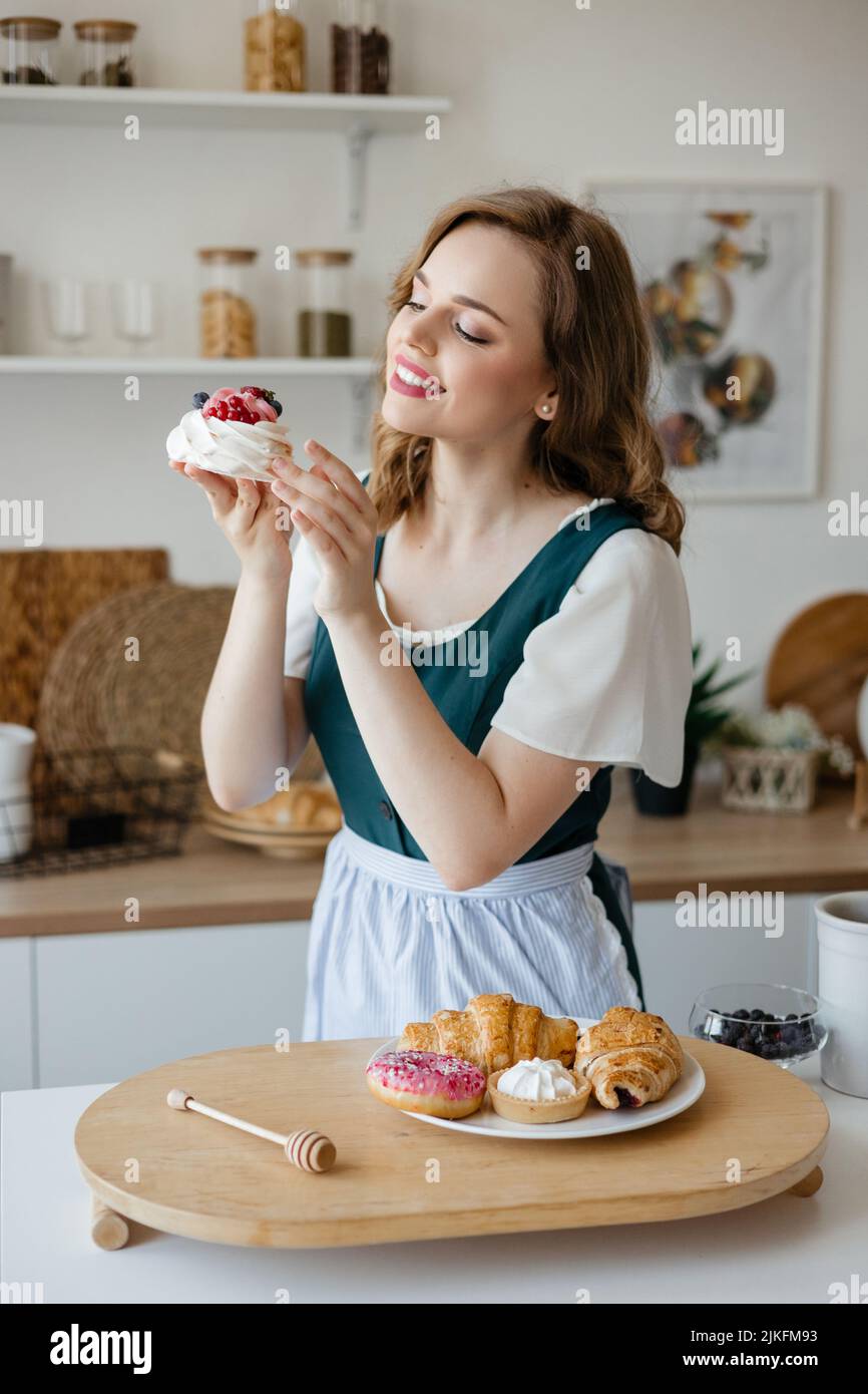 Casalinga che tiene una torta nelle sue mani mentre si alza in cucina Foto Stock