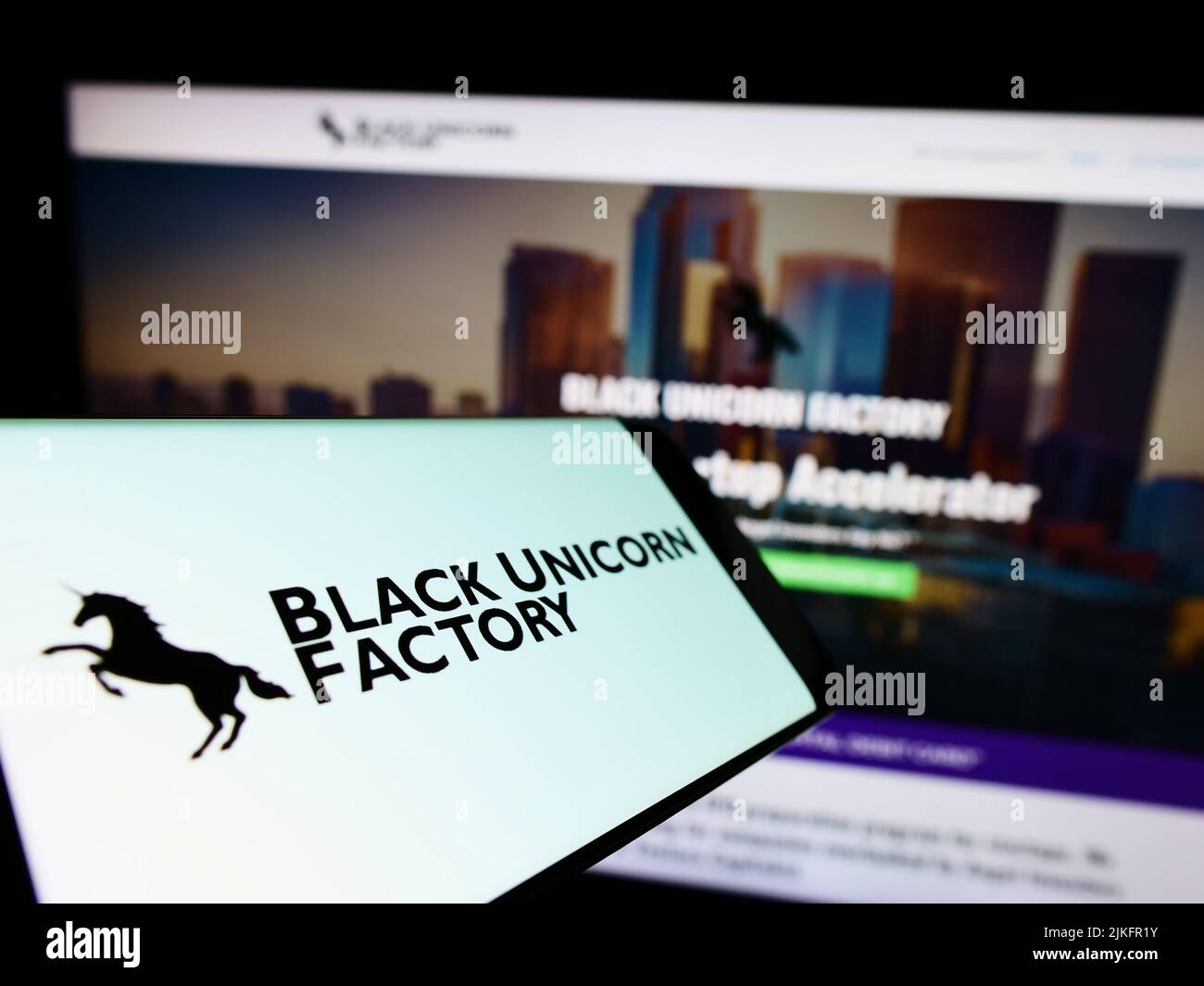 Telefono cellulare con logo della società americana di capitali di rischio Black Unicorn Factory sullo schermo di fronte al sito web. Concentrarsi sul centro del display del telefono. Foto Stock