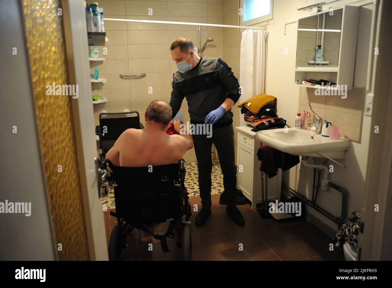 Un'infermiera privata effettua un bagno completo nella casa di un paziente di 69 anni. Foto Stock