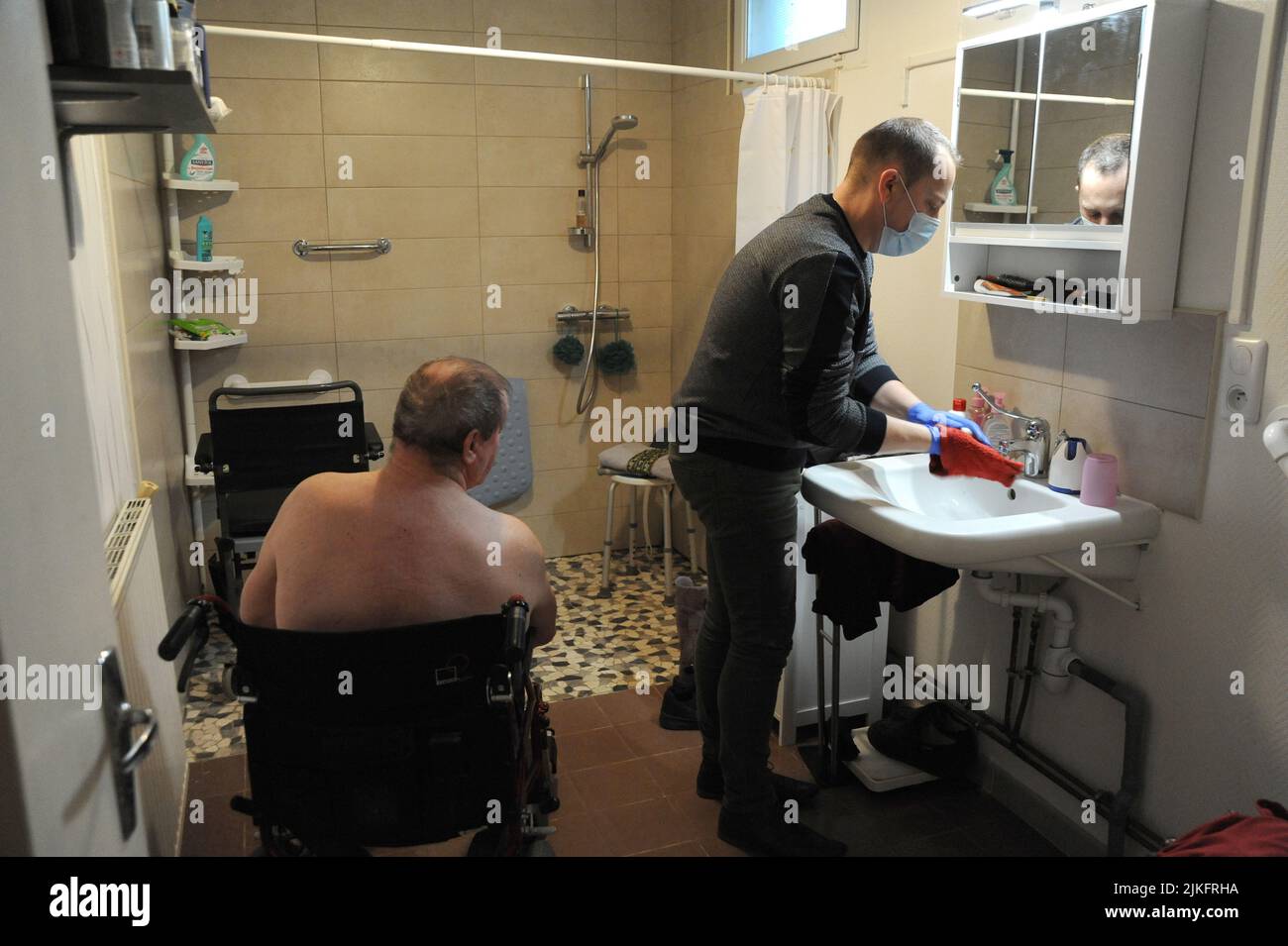 Un'infermiera privata effettua un bagno completo nella casa di un paziente di 69 anni. Foto Stock