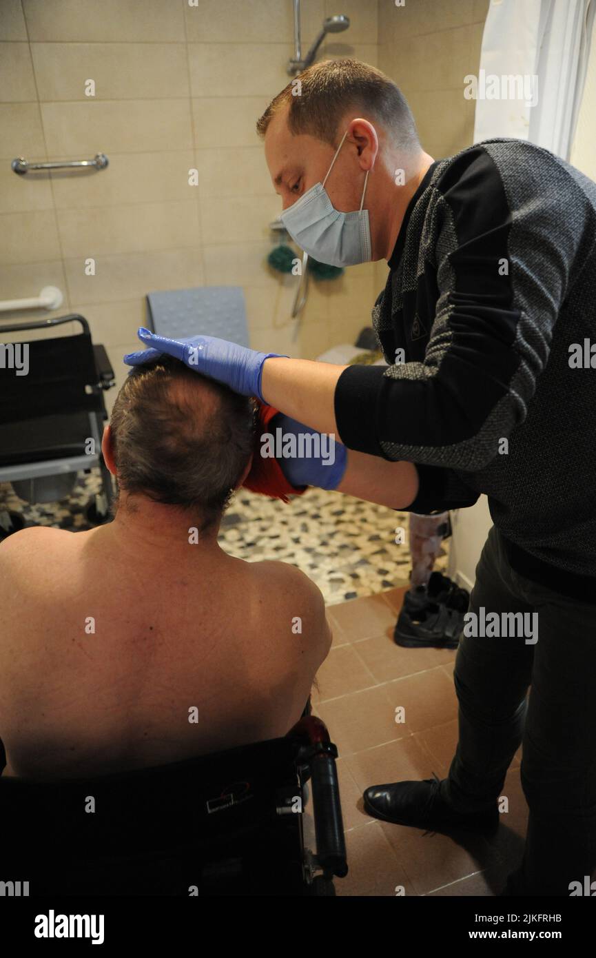 Un'infermiera privata effettua un bagno completo nella casa di un paziente di 69 anni. Foto Stock