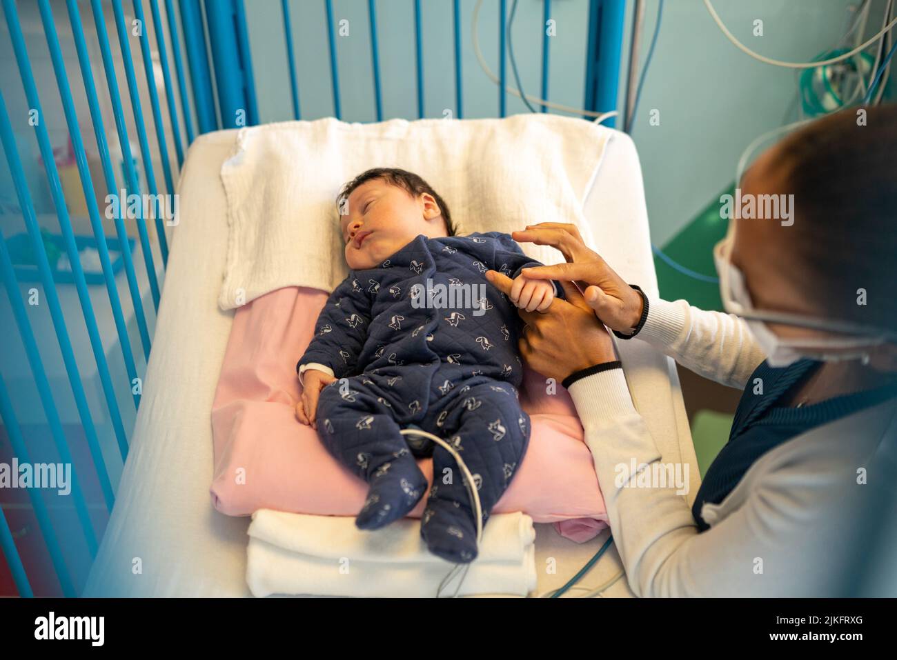 Madre e figlio con bronchiolite con infermiere in un reparto pediatrico ospedaliero. Foto Stock