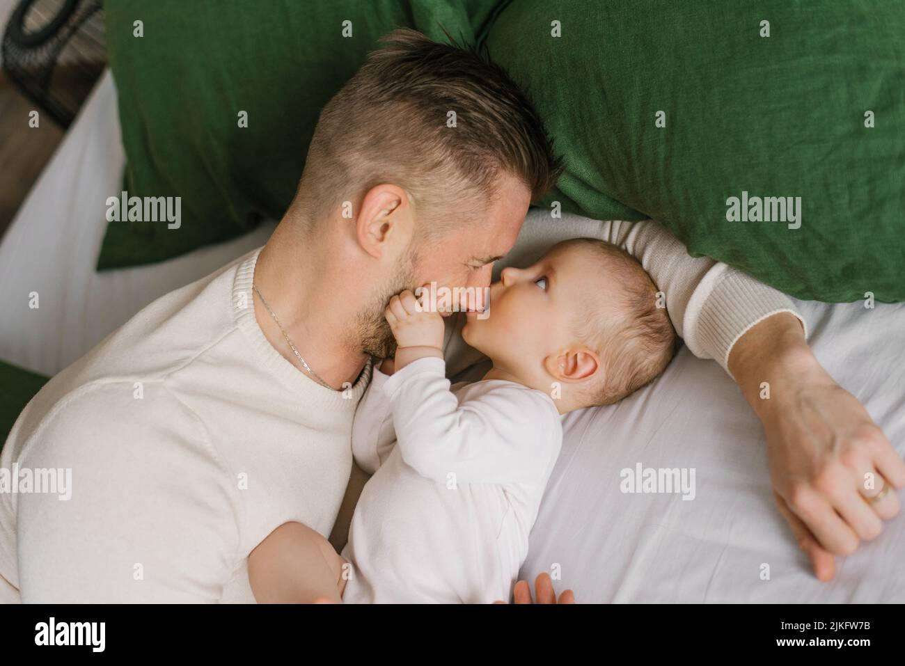 Un padre con un figlio giovane sul letto di casa prima di andare a letto. Foto Stock