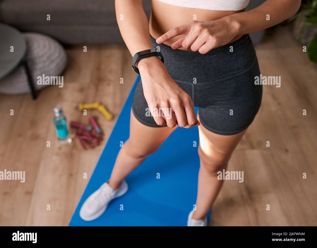 Primo piano di una donna che tocca orologio fitness tracking esercizio post allenamento Foto Stock