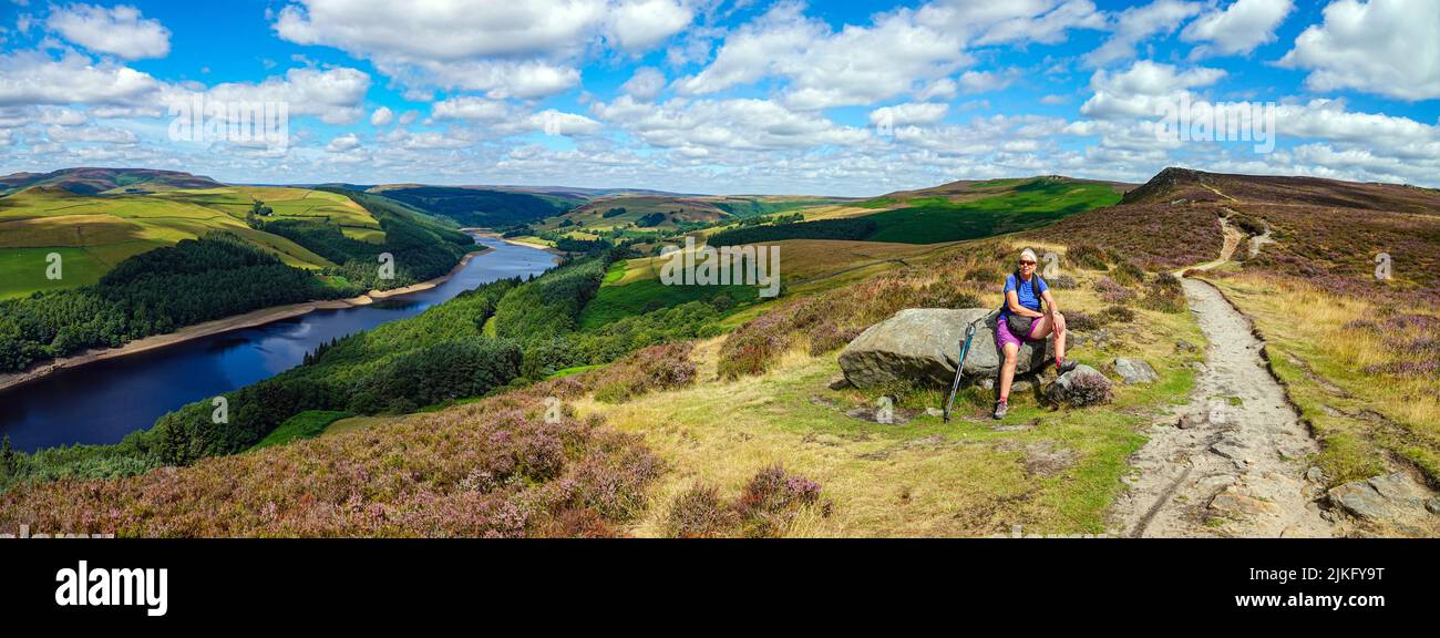 Lone femmina escursionista sopra Ladybower Reservoir visto dall'alto, da Derwent Edge, Peak District National Park, Derbyshire, Regno Unito Foto Stock