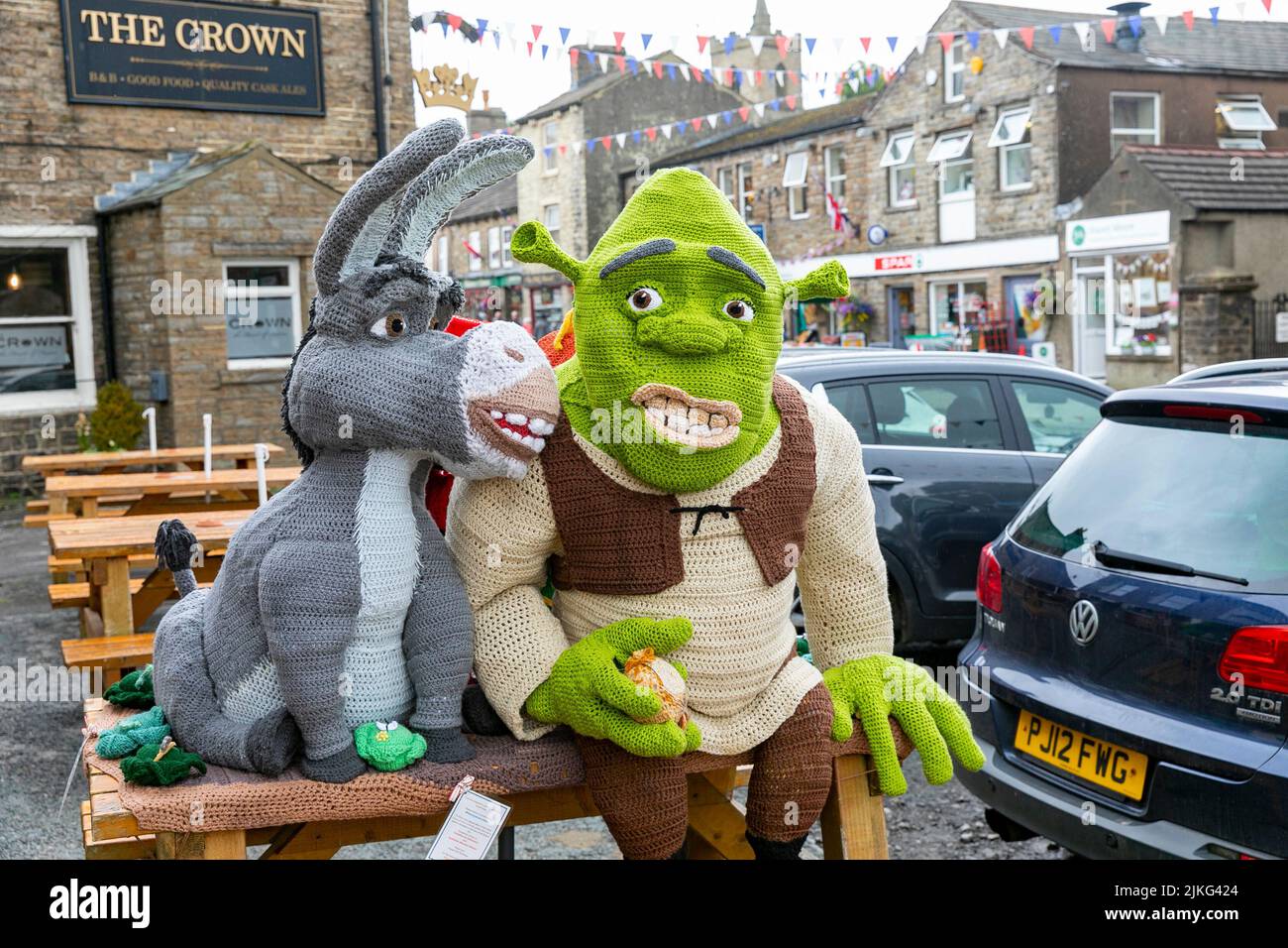 Hawes Village nel Yorkshire Dales, personaggi Shrek a maglia a grandezza naturale esposti per beneficenza raccolta fondi fuori dal Board Inn, Yorkshire, Inghilterra Foto Stock