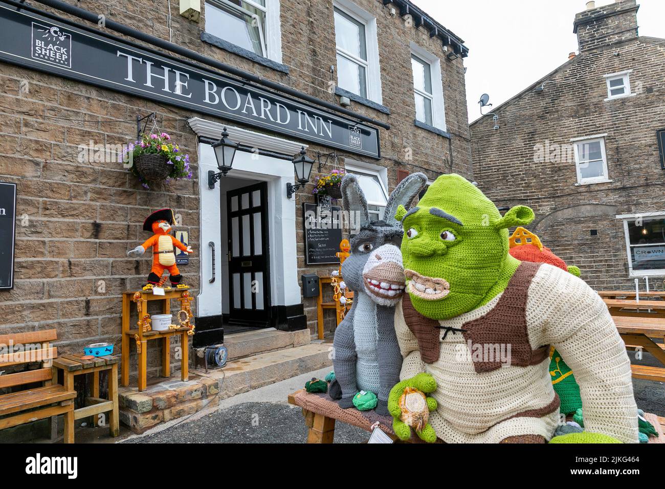 Hawes Village nel Yorkshire Dales, personaggi Shrek a maglia a grandezza naturale esposti per beneficenza raccolta fondi fuori dal Board Inn, Yorkshire, Inghilterra Foto Stock