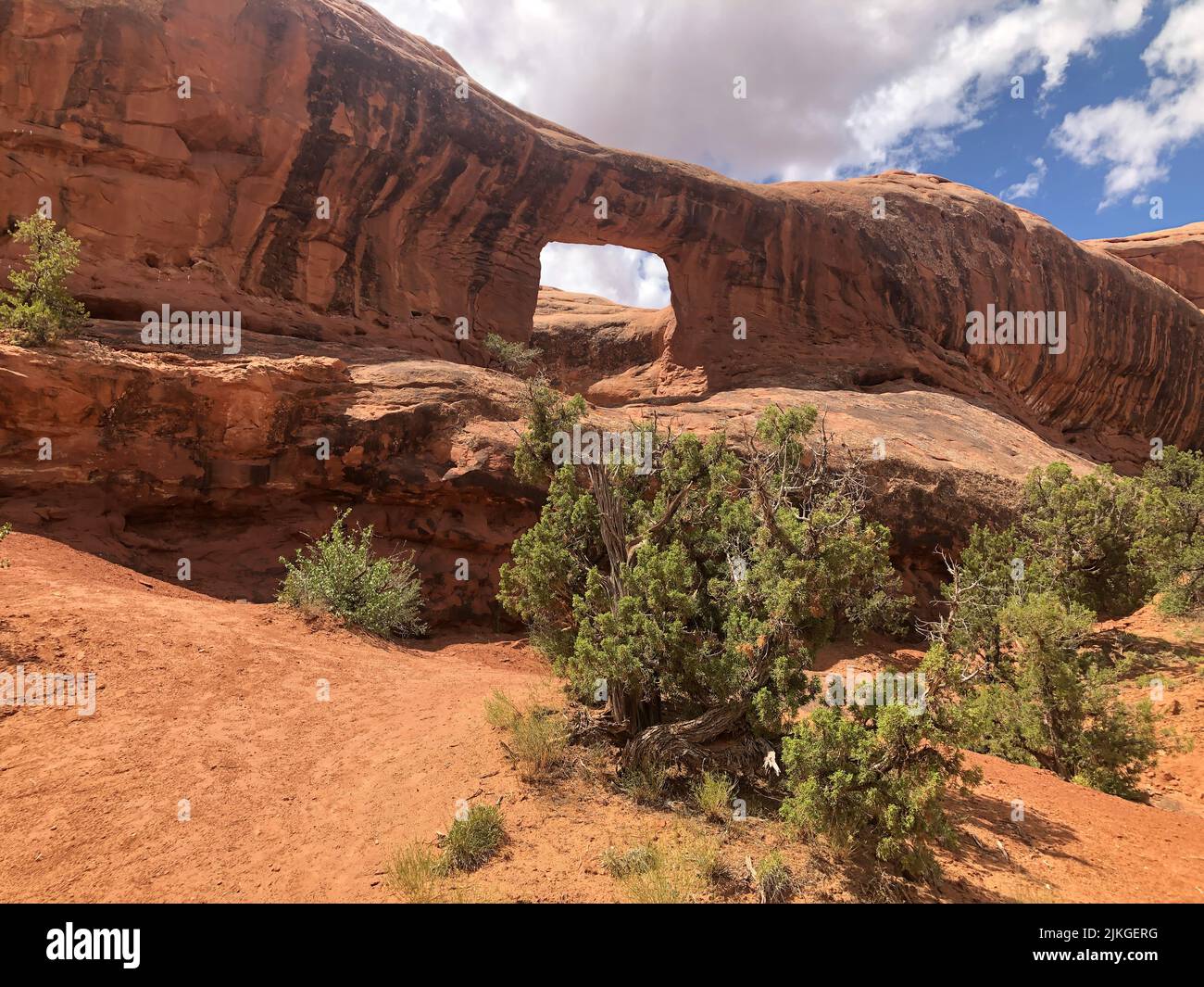 Cornice Arch con strisce di vernice del deserto nella pietra arenaria di Lone Rock Butte Entrada vicino a Moab, Utah. Foto Stock