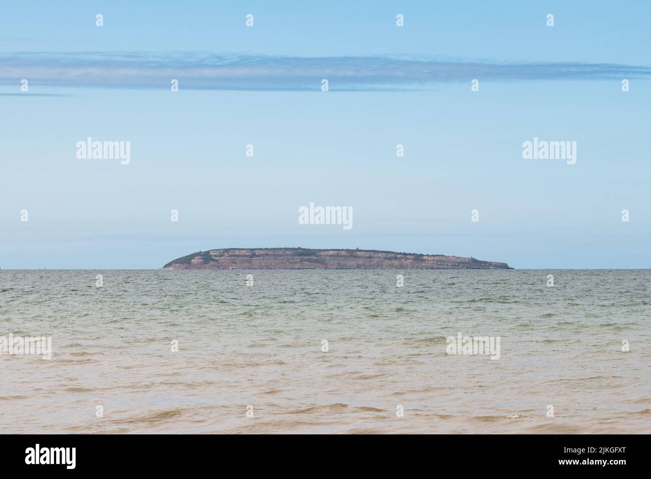 Puffin Island appena al largo della costa di Anglesey, vista dalla spiaggia di Penmaenmawr, Galles Foto Stock