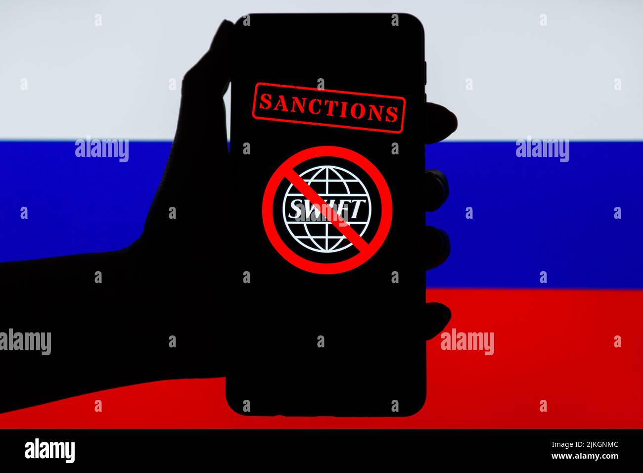 Ucraina, Kiev - Febbraio, 23 2022: Silhouette di mano nera mobile con logo SWIFT barrato e bandiera russa sullo sfondo. Sanzioni contro la Russia, disconnessione dal concetto SWIFT. Foto Stock