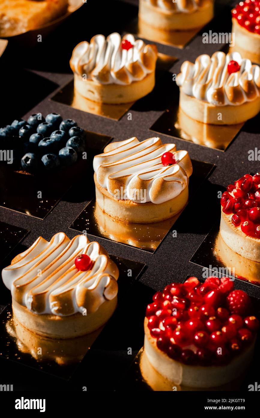 Il primo piano di diversi dolci crostata con diversi bacca, verticale Foto Stock