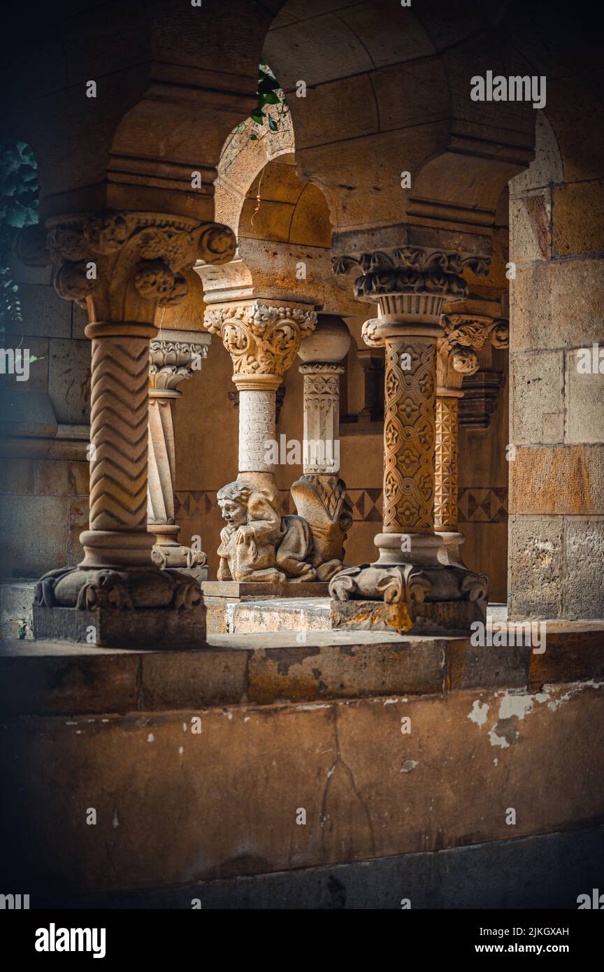 Una scultura di un uomo ai piedi delle colonne architettoniche del Monastero storico Foto Stock