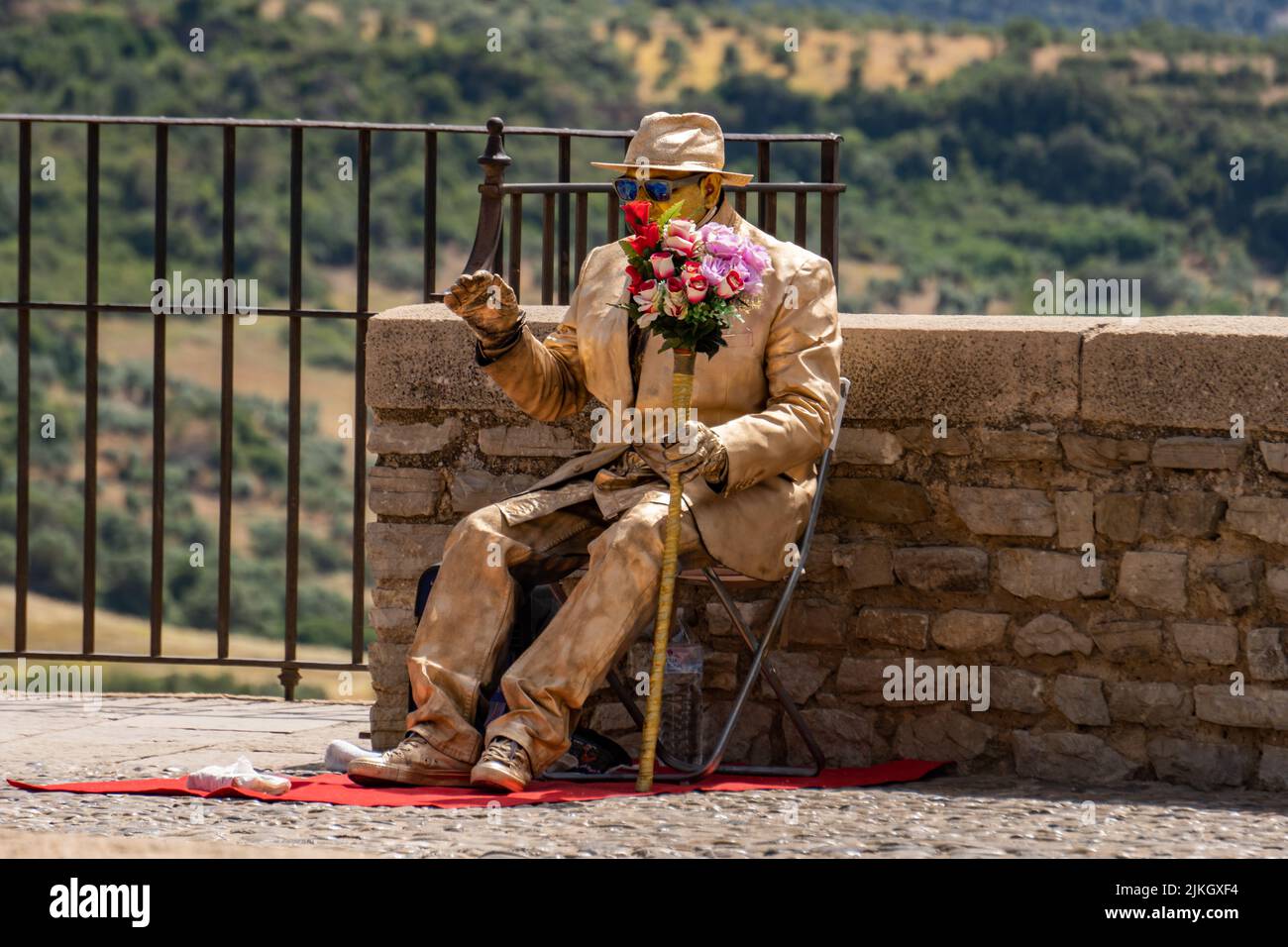 ronda,malaga,spagna 20 giugno 2022 artista di strada in abbigliamento color oro che si esibisce in un parco Foto Stock