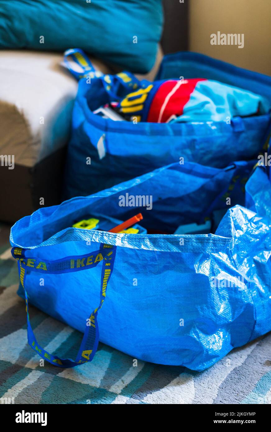 Un primo piano di due borse Ikea blu in plastica su un pavimento in moquette. Foto Stock