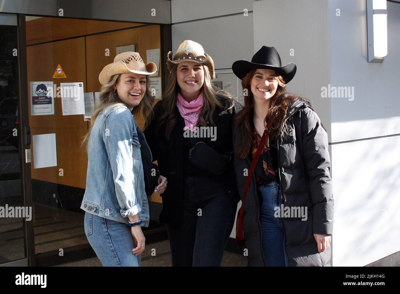 Belle donne giovani felici in cappelli cowboy nel centro di Vancouver, British Columbia, Canada Foto Stock