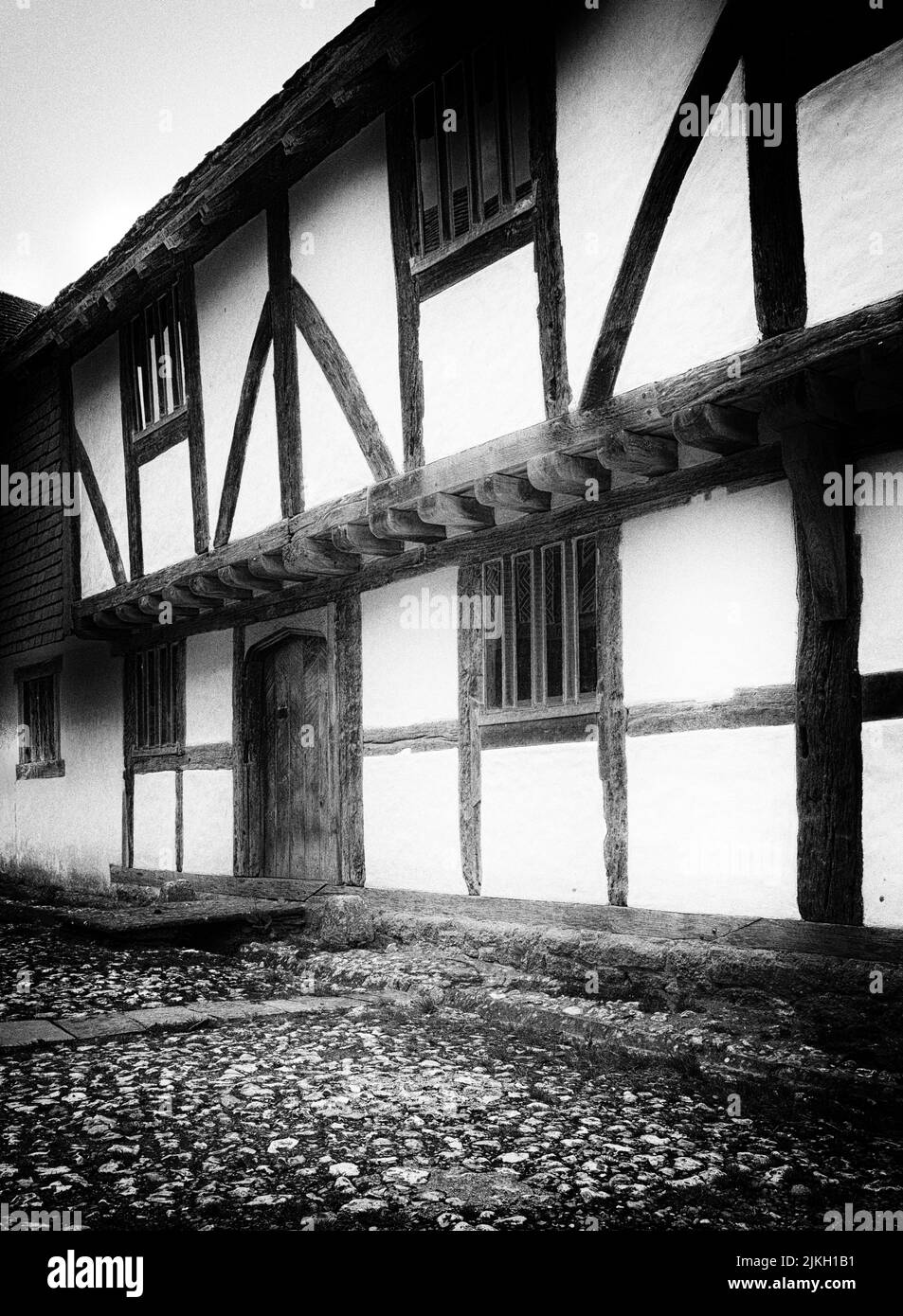 Casa inglese Tudor a graticcio e una strada acciottolata. Foto Stock