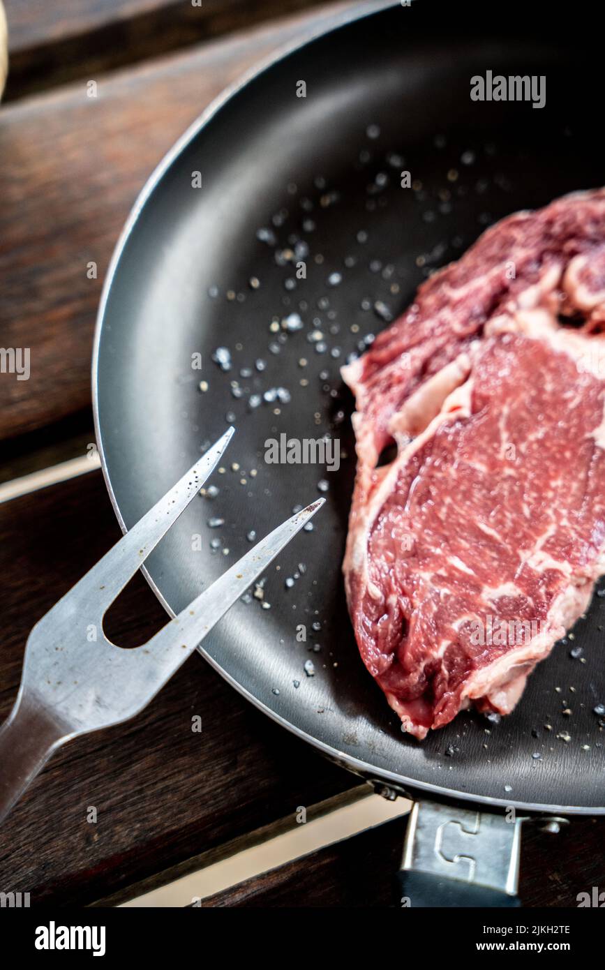 Un pezzo di bistecca di manzo crudo con spezie Foto Stock