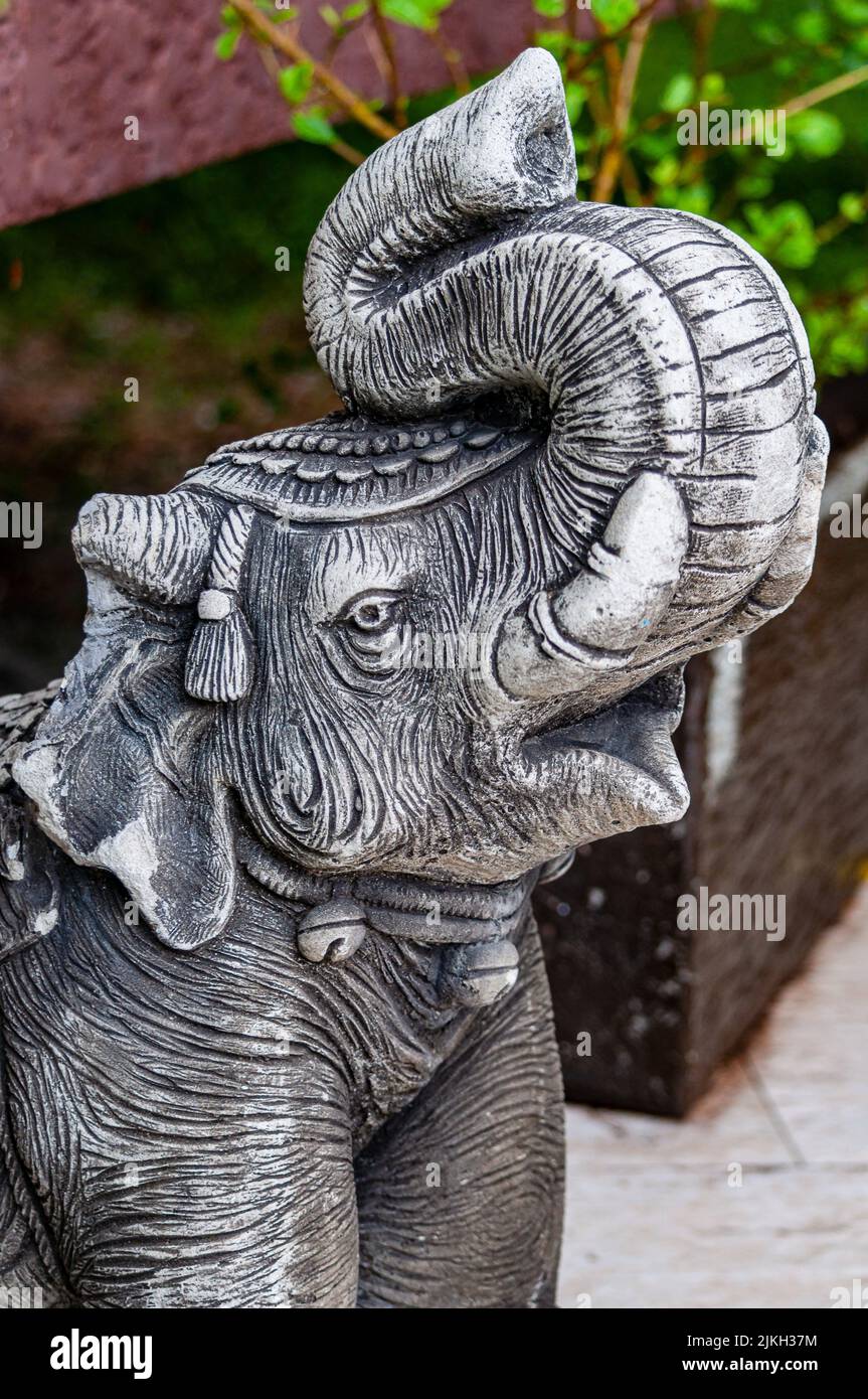 Un primo piano verticale di una scultura di elefante nel giardino Foto Stock