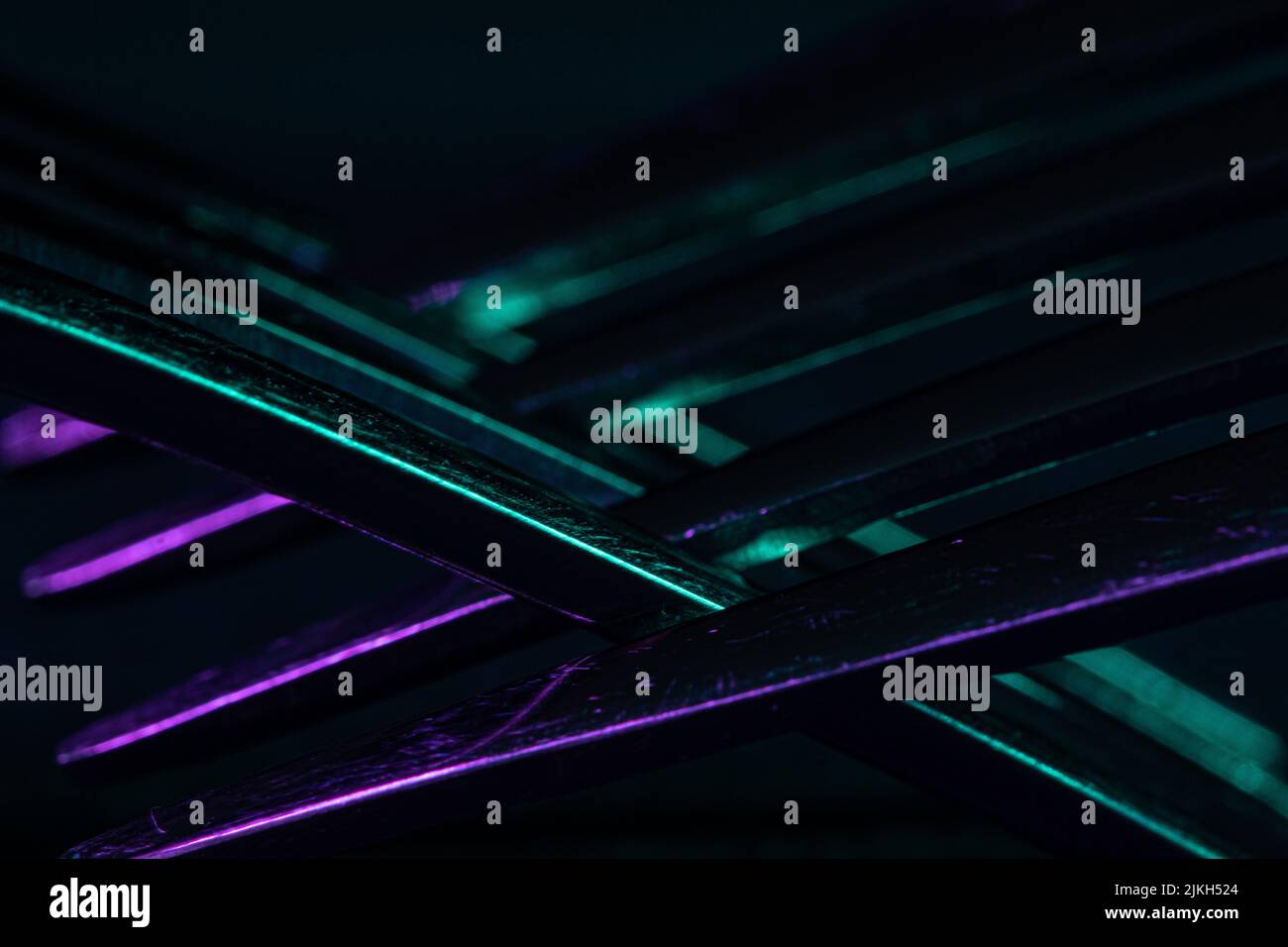 Un primo piano di forchette in argento che riflettono luci colorate su uno sfondo nero Foto Stock