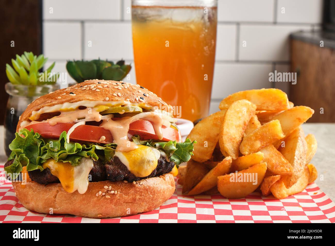 Un primo piano di un cheeseburger con patatine fritte Foto Stock