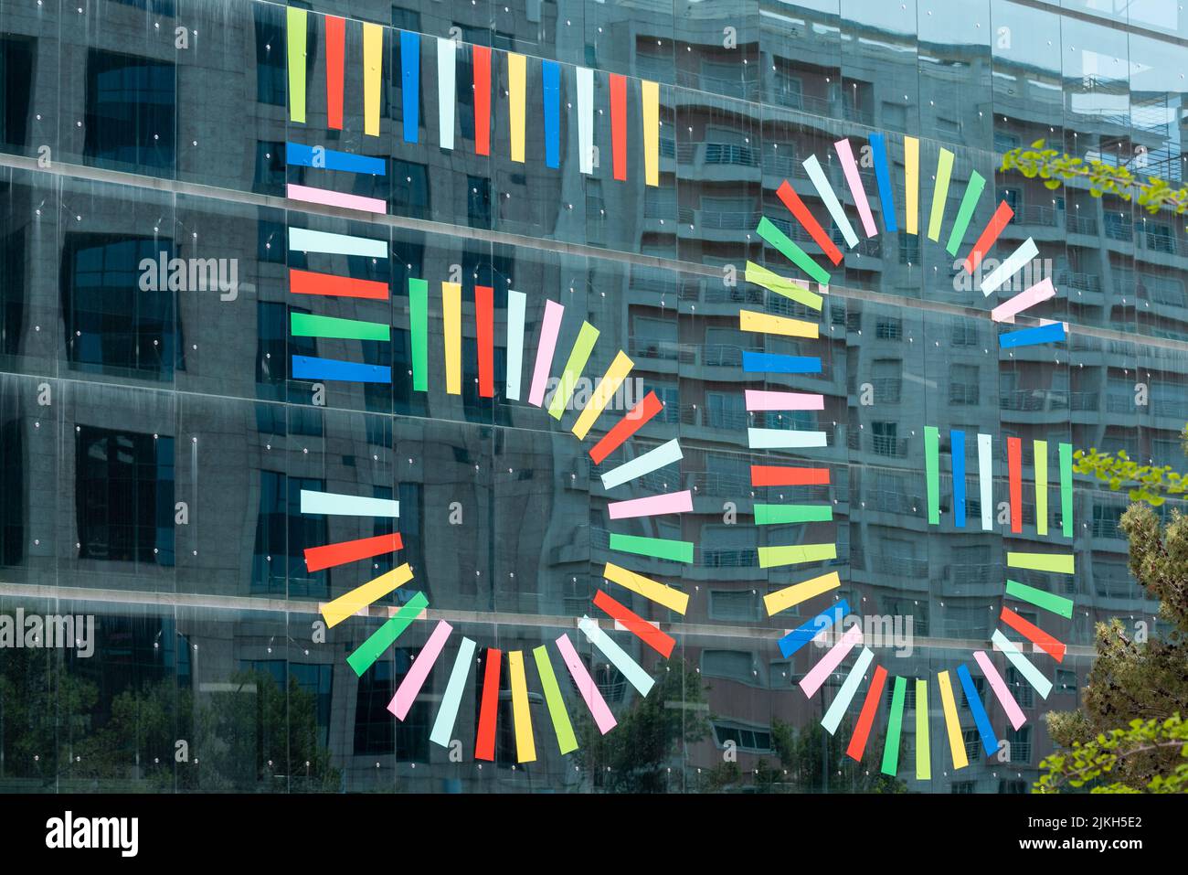 La colorata pubblicità della nuova tecnologia 5G sulla facciata in vetro di un edificio moderno Foto Stock