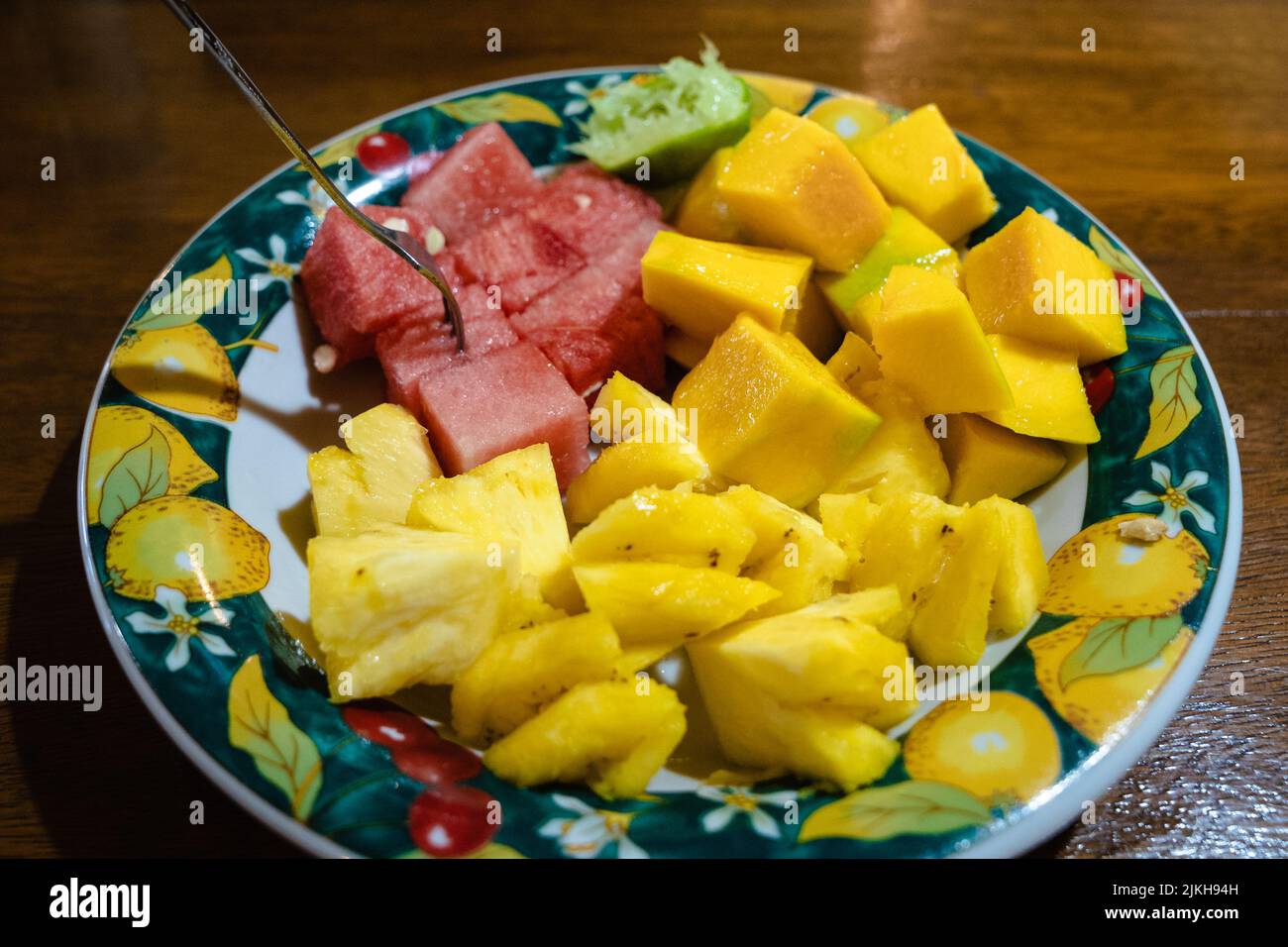 Un primo piano di anguria, ananas e melone a fette su un piatto con forchetta Foto Stock