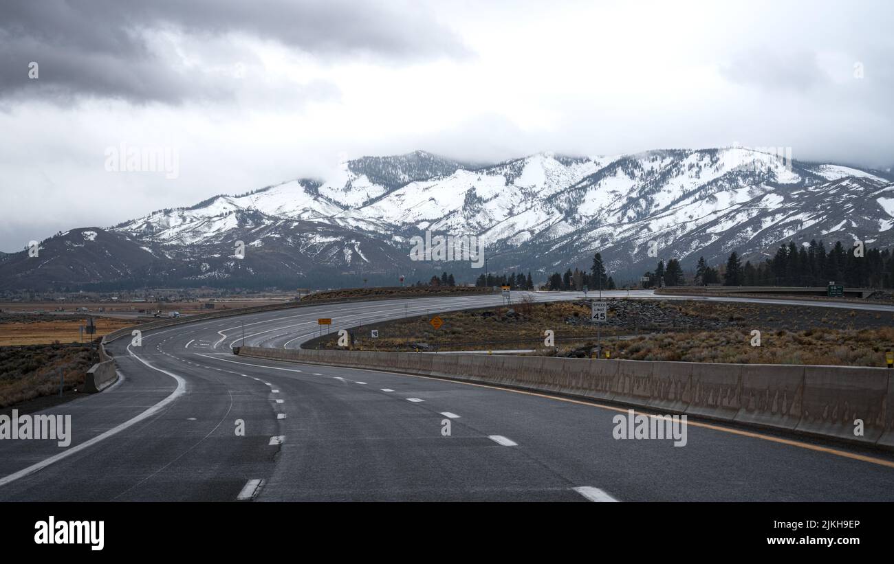 Una vista panoramica della vecchia autostrada US 395 con montagne innevate a distanza. A Washoe Valley, Nevada Foto Stock