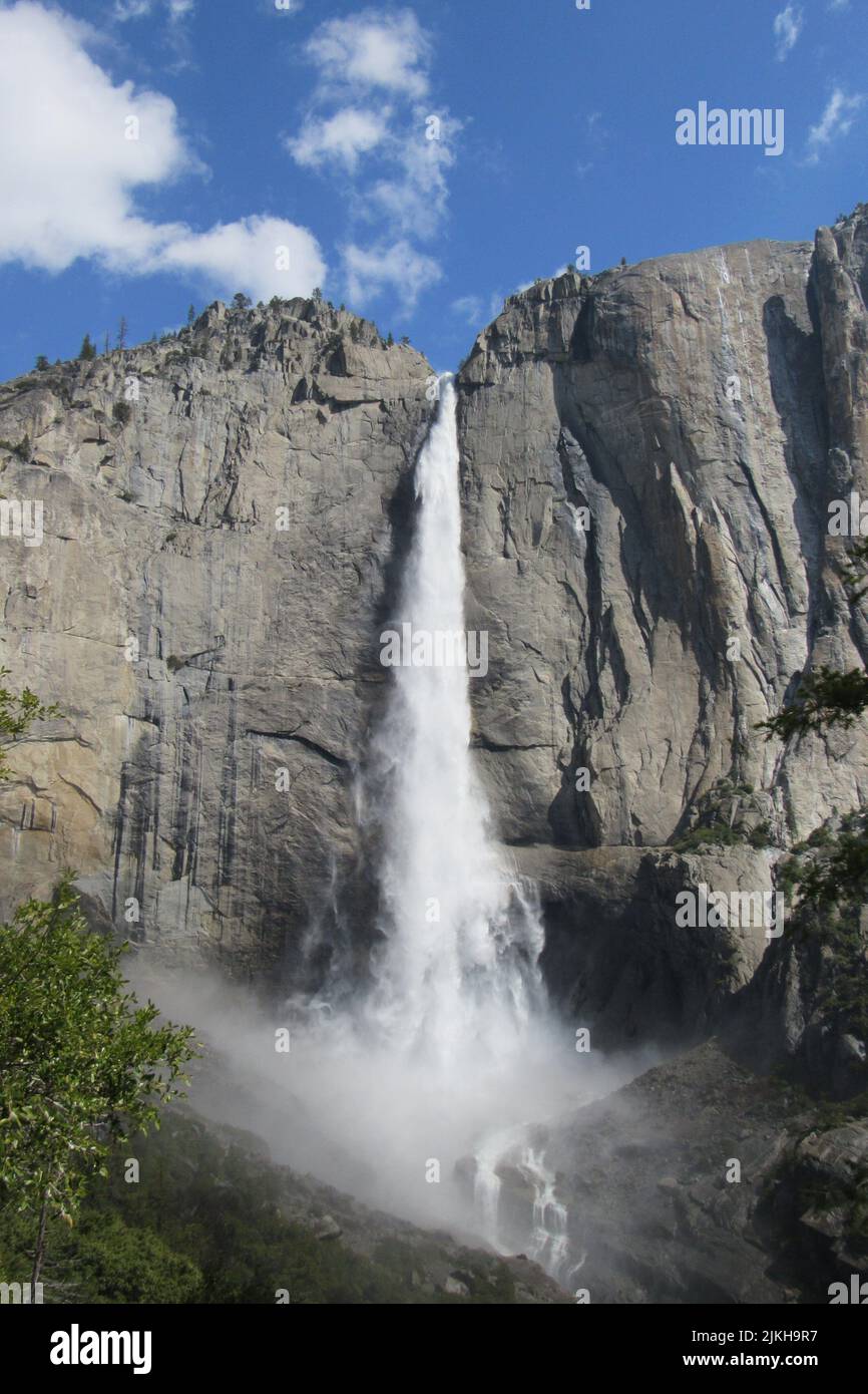 Uno scatto verticale di una splendida cascata che scorre attraverso le ...